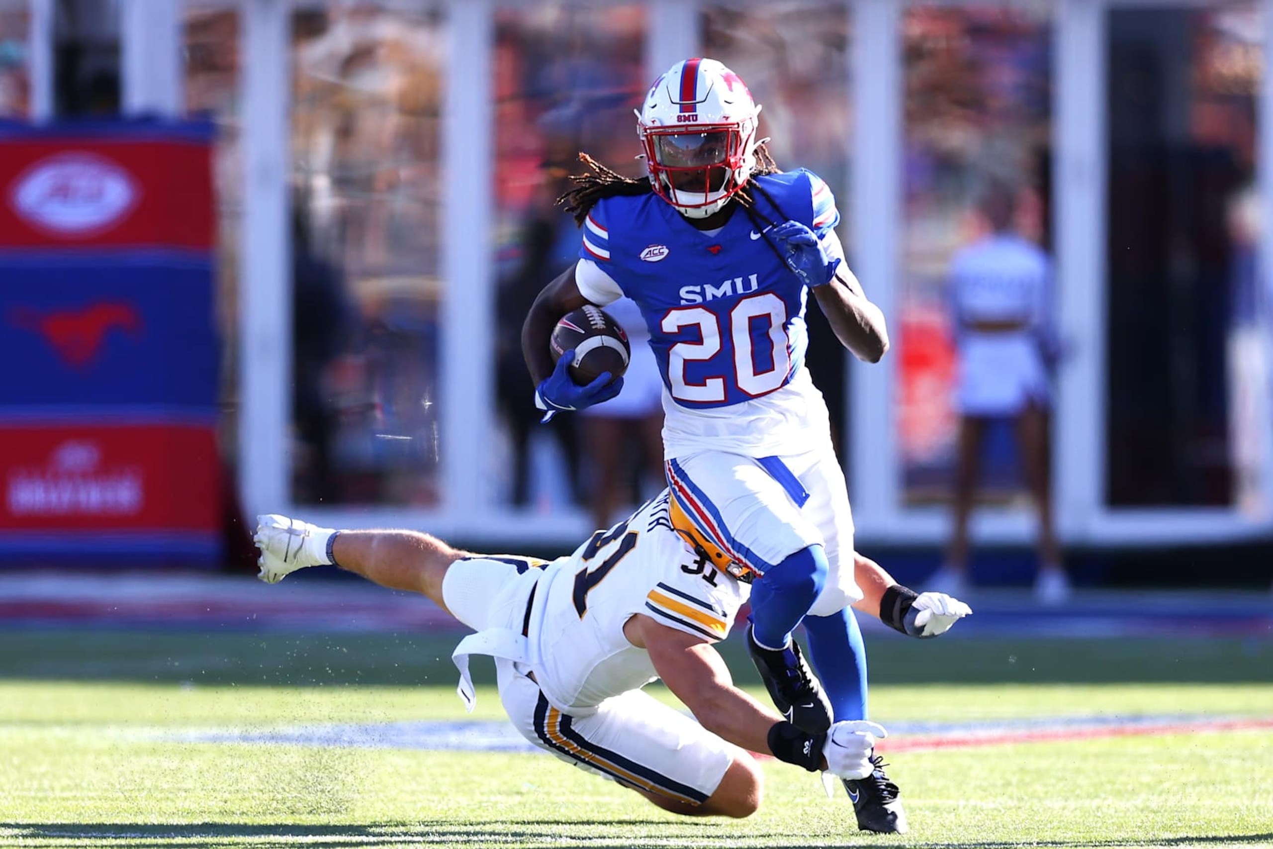 DALLAS, TEXAS - NOVEMBER 30: Derrick McFall #20 of the Southern Methodist Mustangs avoids a tackle from Hunter Barth #31 of the California Golden Bears during the first half at Gerald J. Ford Stadium on November 30, 2024 in Dallas, Texas. (Photo by Sam Hodde/Getty Images)