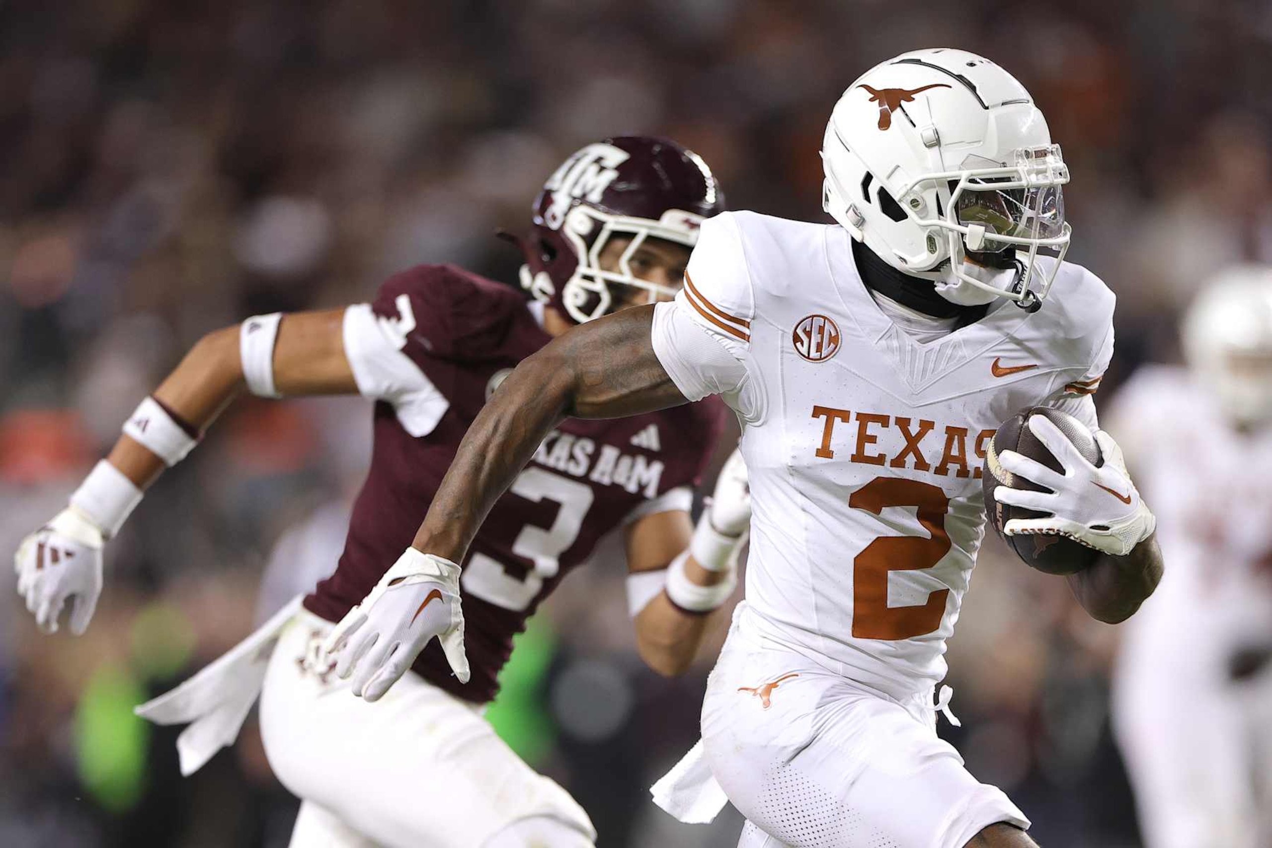 COLLEGE STATION, TEXAS - NOVEMBER 30: Derek Williams Jr. #2 of the Texas Longhorns runs the ball against Marcus Ratcliffe #3 of the Texas A&M Aggies during the third quarter at Kyle Field on November 30, 2024 in College Station, Texas. (Photo by Alex Slitz/Getty Images)