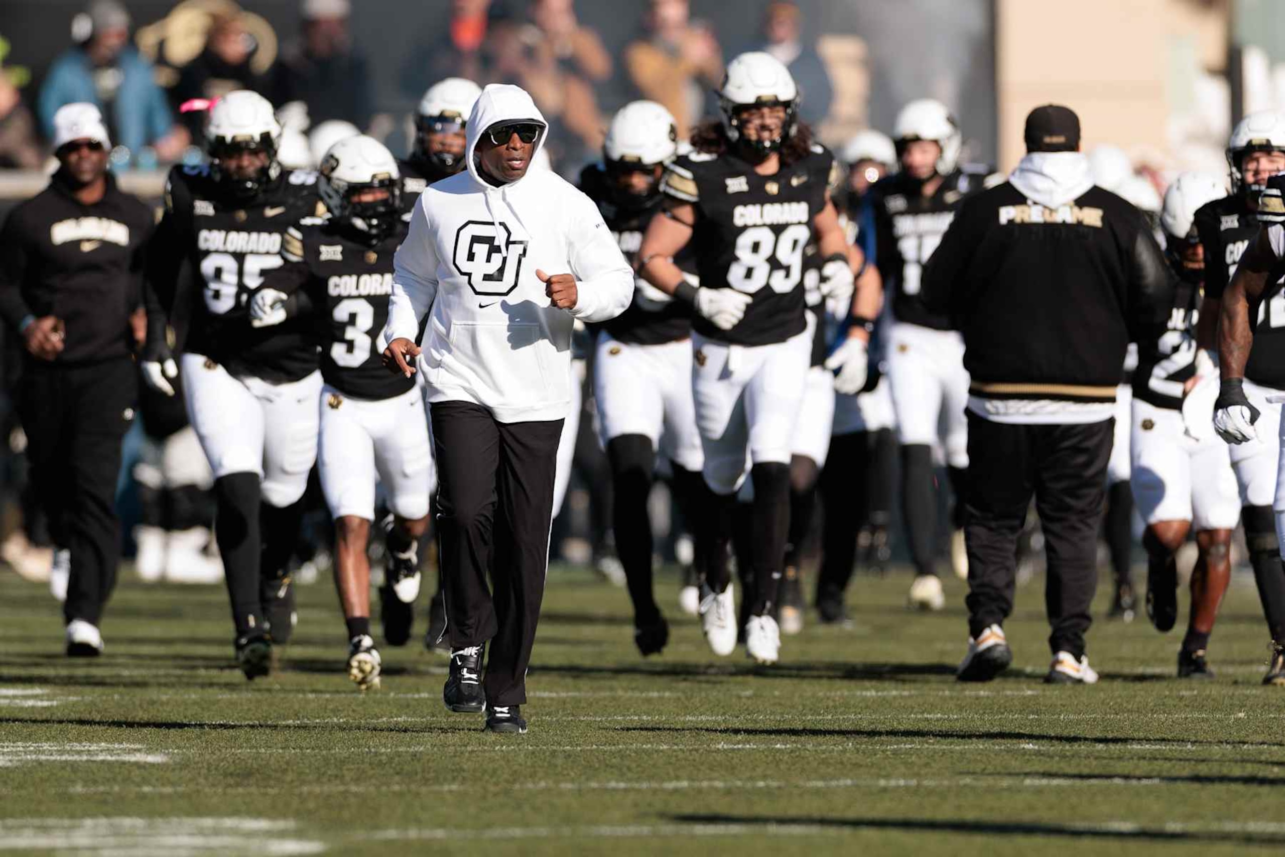 BOULDER, COLORADO - NOVEMBER 29: Head coach Deion Sanders of the Colorado Buffaloes runs out with his team prior to the game against the Oklahoma State Cowboys at Folsom Field on November 29, 2024 in Boulder, Colorado. (Photo by Andrew Wevers/Getty Images)