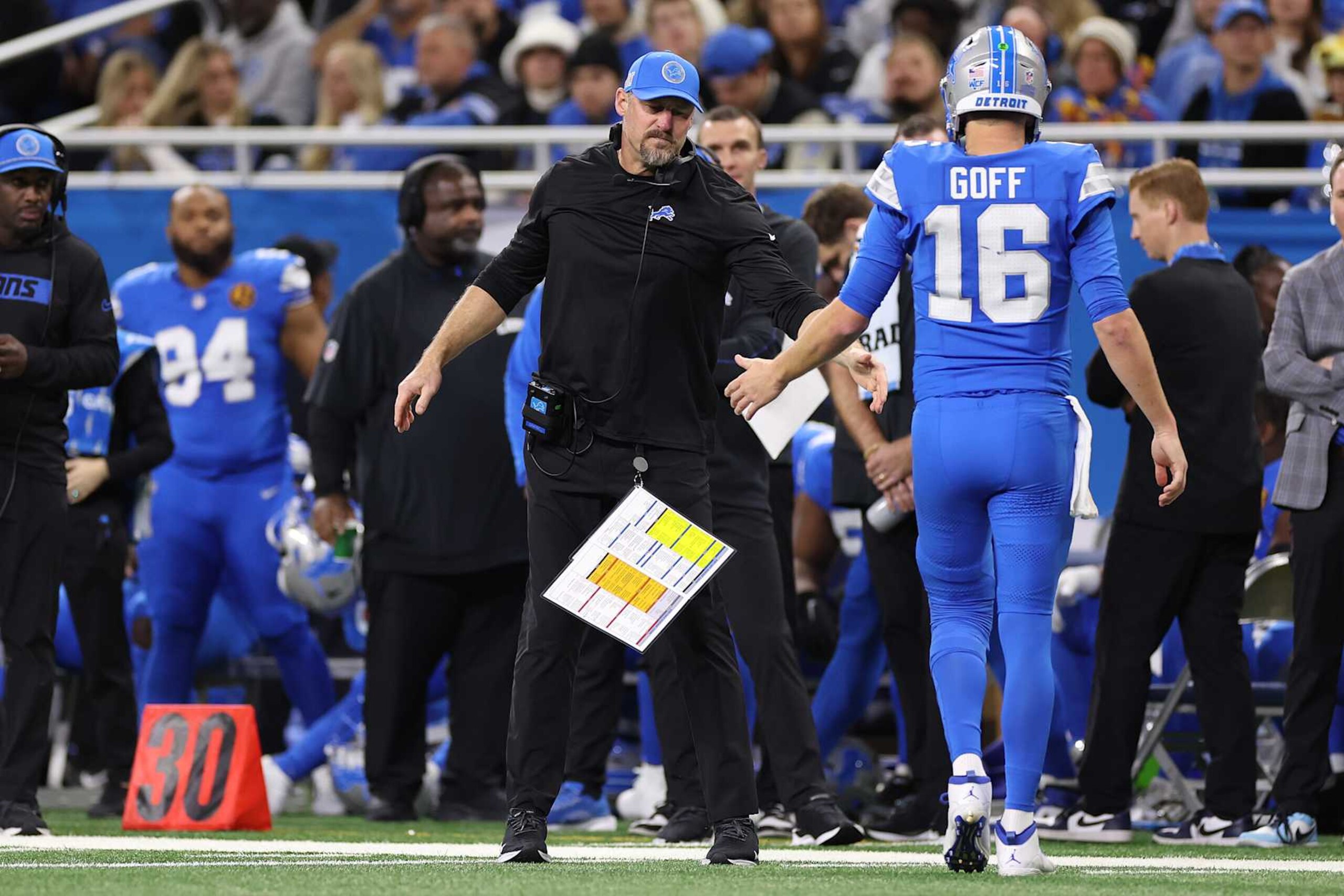 DETROIT, MICHIGAN - NOVEMBER 28: Head coach Dan Campbell 
 high fives Jared Goff #16 of the Detroit Lions during the second quarter of a game against the Chicago Bears at Ford Field on November 28, 2024 in Detroit, Michigan. (Photo by Mike Mulholland/Getty Images)