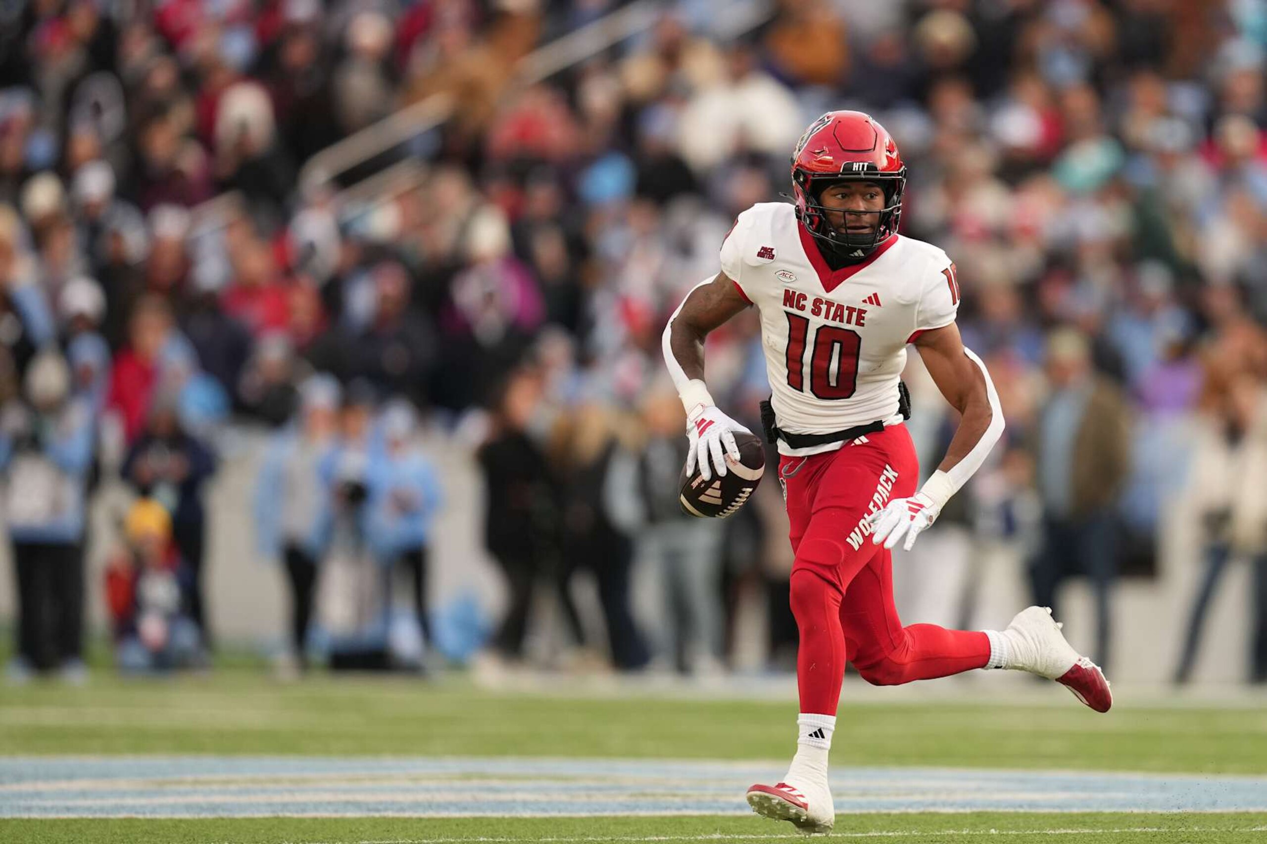 CHAPEL HILL, NORTH CAROLINA - NOVEMBER 30: Kevin Concepcion #10 of the North Carolina State Wolfpack rolls out against the North Carolina Tar Heels during the game at Kenan Memorial Stadium on November 30, 2024 in Chapel Hill, North Carolina. The Wolfpack won 35-30. (Photo by Grant Halverson/Getty Images)