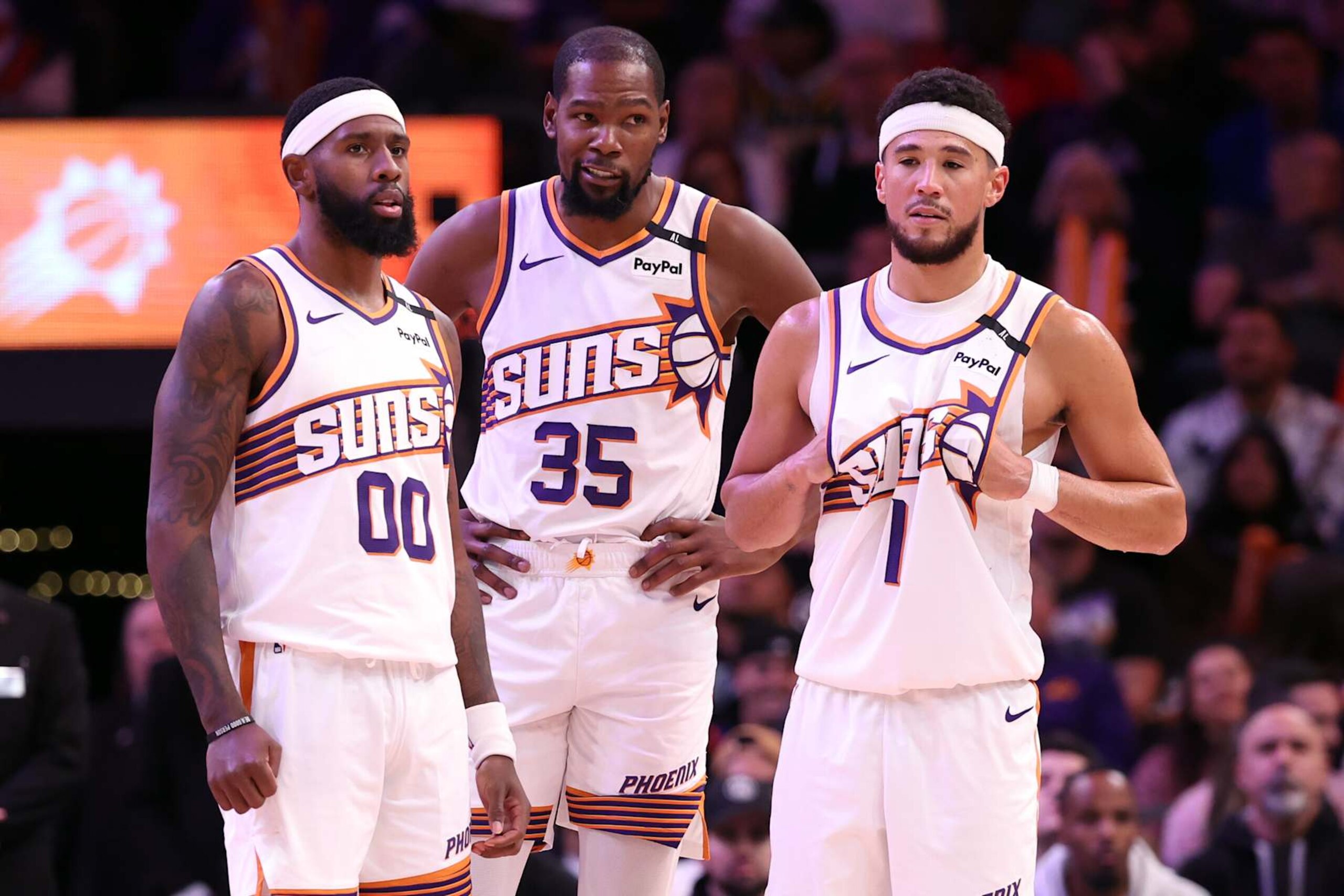 PHOENIX, ARIZONA - NOVEMBER 04: (L-R) Royce O'Neale #00 of the Phoenix Suns, Kevin Durant #35 and Devin Booker #1 stand on the floor during a timeout in the game /apl at Footprint Center on November 04, 2024 in Phoenix, Arizona. The Suns defeated the 76ers 118-116. NOTE TO USER: User expressly acknowledges and agrees that, by downloading and or using this photograph, User is consenting to the terms and conditions of the Getty Images License Agreement.  (Photo by Chris Coduto/Getty Images)