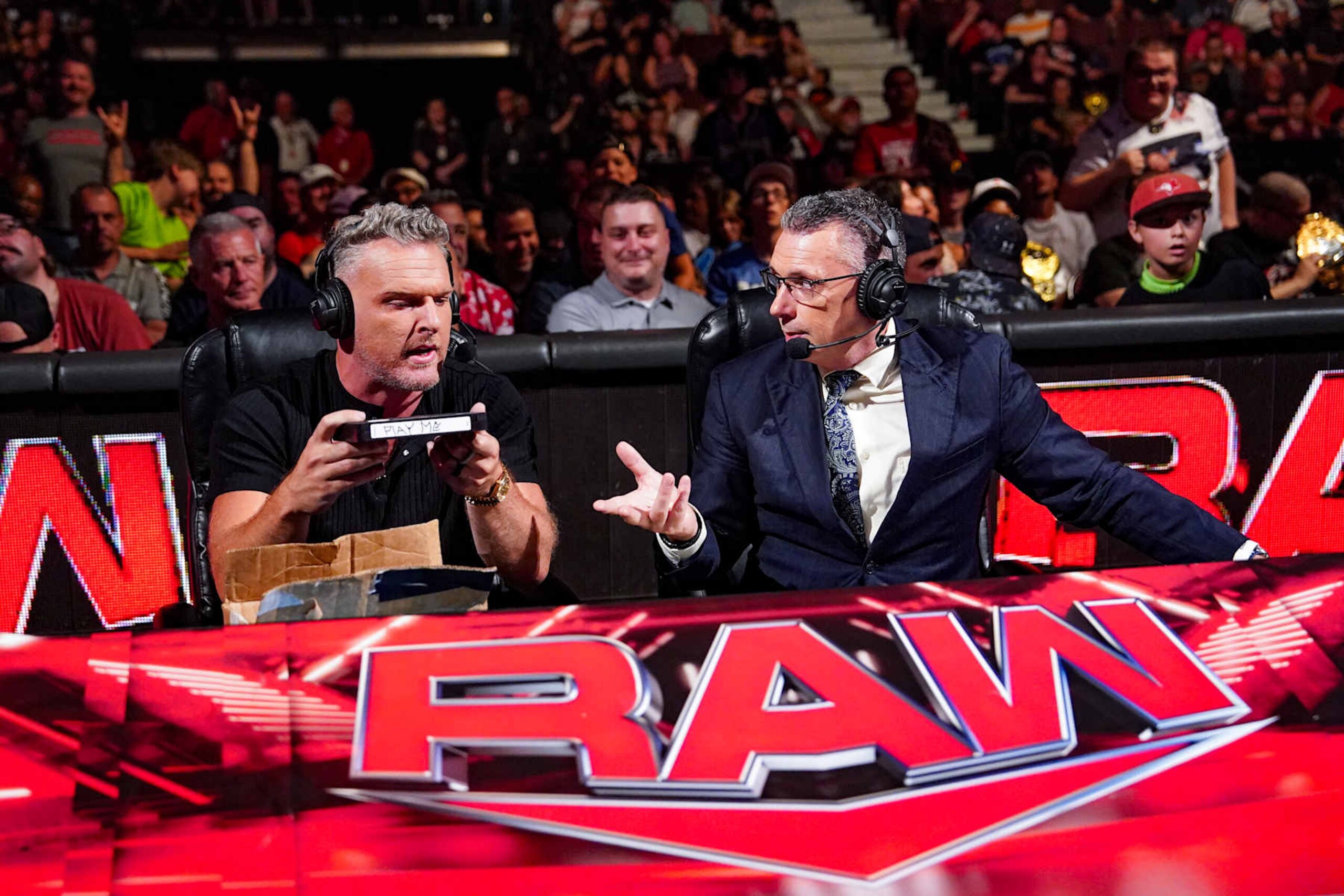 OTTAWA, CANADA - JULY 8: Pat McAfee and Michael Cole open the package left by Nikki Cross during Monday Night RAW at Canadian Tire Centre on July 8, 2024 in Ottawa, Ontario.  (Photo by WWE/Getty Images)