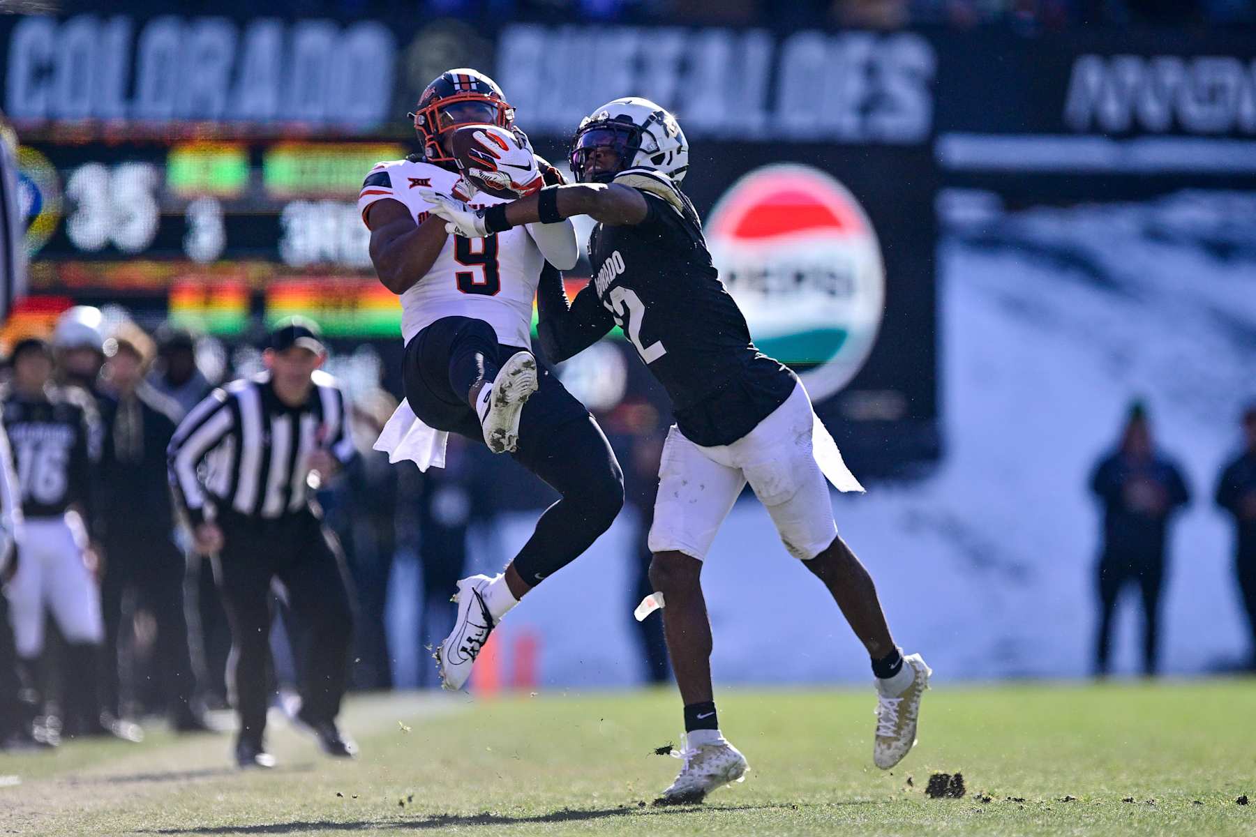 BOULDER, CO - NOVEMBER 29:  Travis Hunter #12 of the Colorado Buffaloes defends a pass intended for Ayo Shotomide-King #9 of the Oklahoma State Cowboys in the third quarter at Folsom Field on November 29, 2024 in Boulder, Colorado. (Photo by Dustin Bradford/Getty Images)