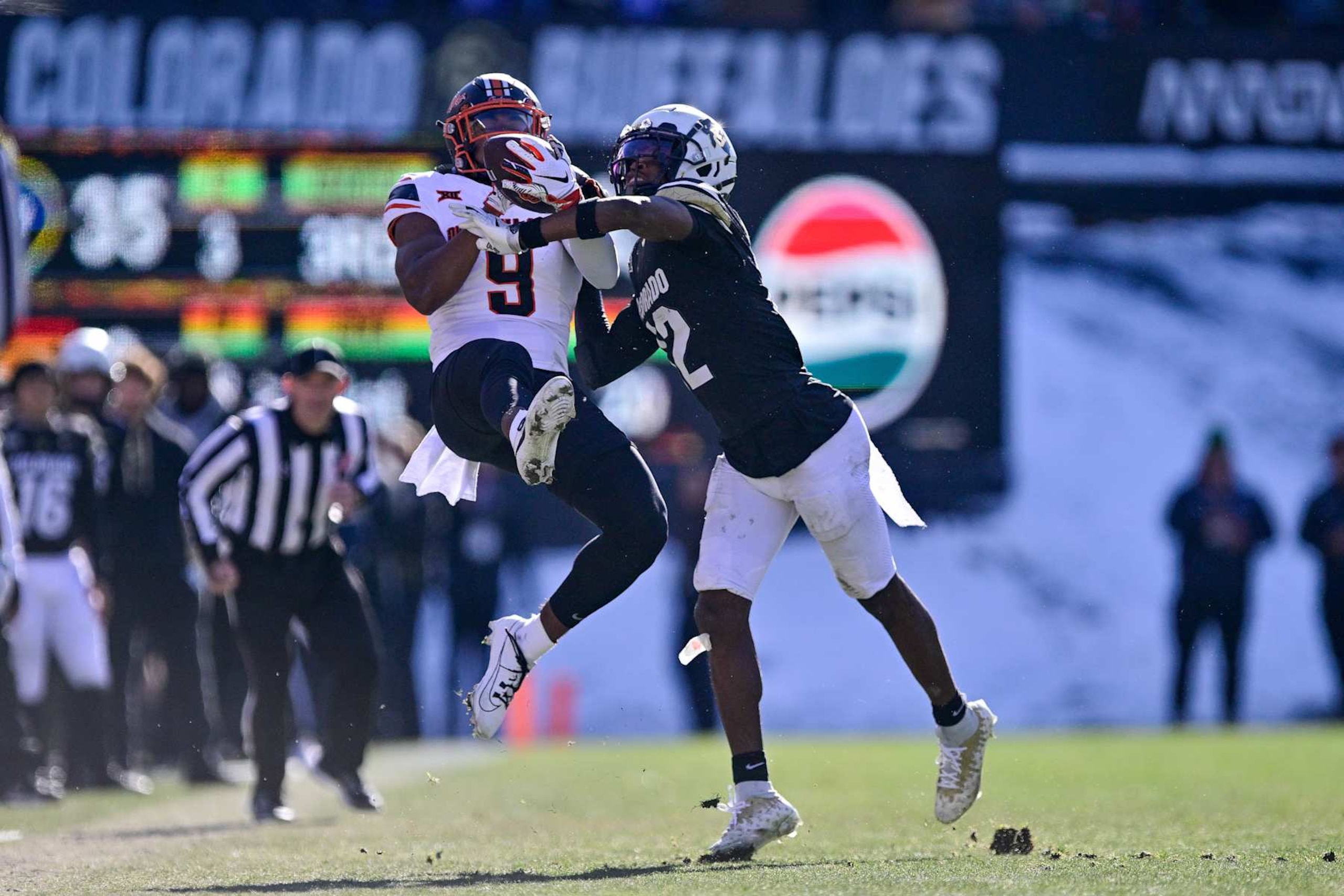 BOULDER, CO - NOVEMBER 29:  Travis Hunter #12 of the Colorado Buffaloes defends a pass intended for Ayo Shotomide-King #9 of the Oklahoma State Cowboys in the third quarter at Folsom Field on November 29, 2024 in Boulder, Colorado. (Photo by Dustin Bradford/Getty Images)