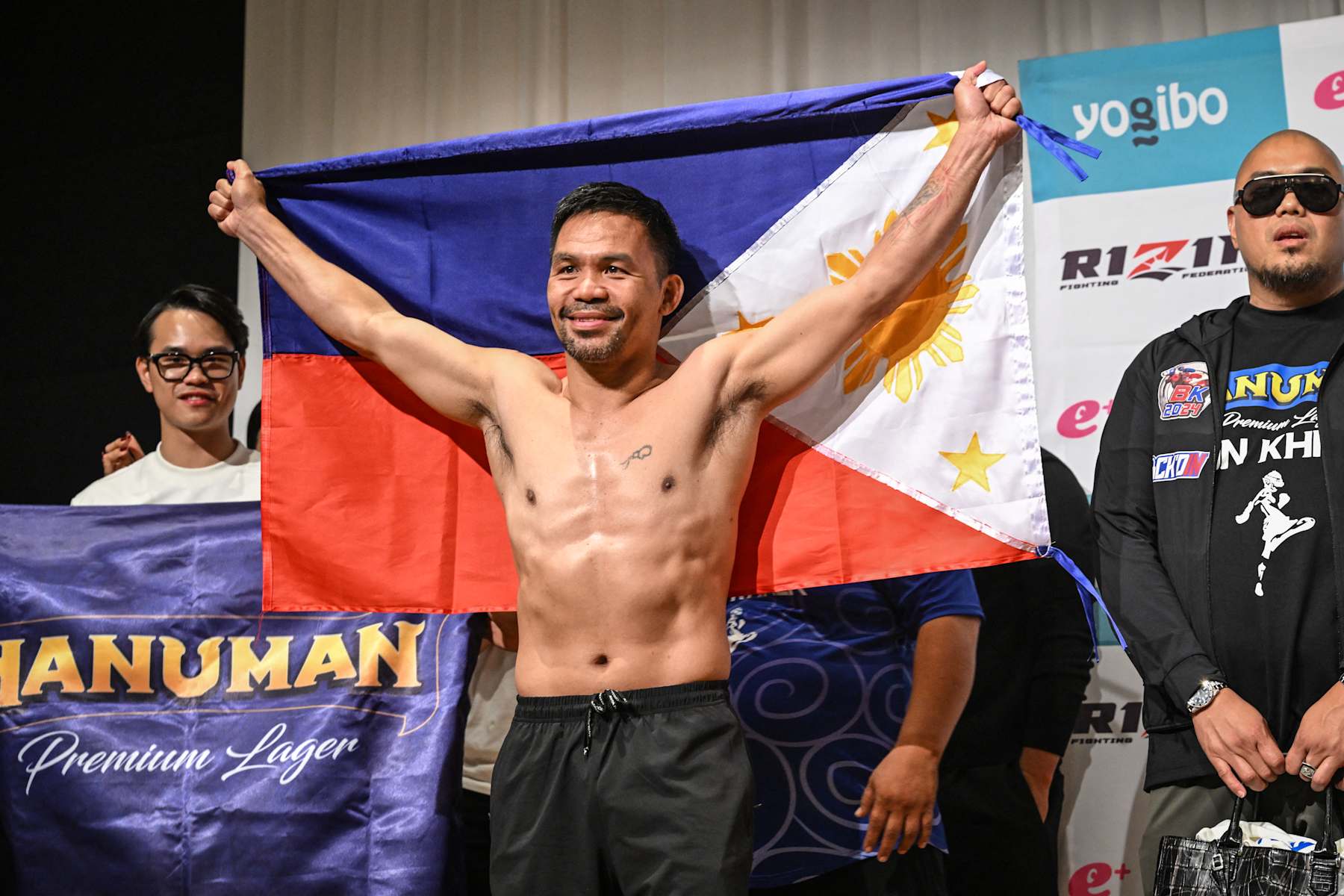 Philippine boxing legend Manny Pacquiao poses with the Philippines flag following the official weigh-in at a hotel in Tokyo on July 27, 2024 ahead of his July 28 three-round exhibition boxing match against Japanese mixed martial artist Rukiya Anpo. (Photo by Yuichi YAMAZAKI / AFP) (Photo by YUICHI YAMAZAKI/AFP via Getty Images)