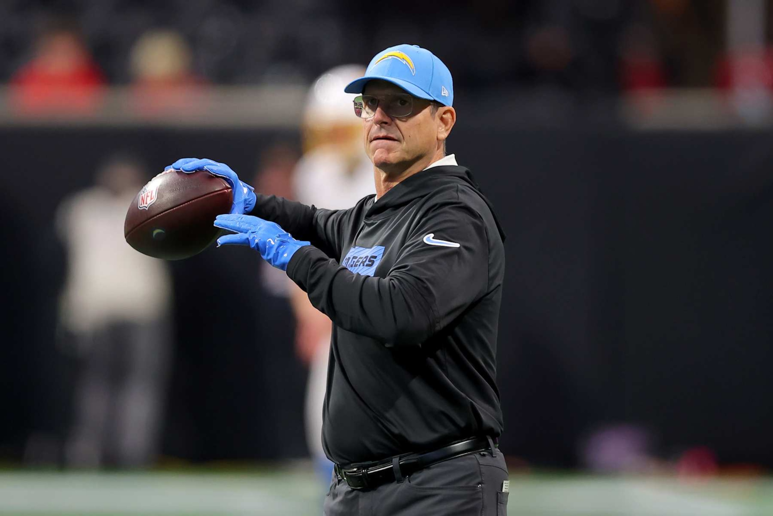 ATLANTA, GEORGIA - DECEMBER 01: Head coach Jim Harbaugh of the Los Angeles Chargers throws a football before the game against the Atlanta Falcons at Mercedes-Benz Stadium on December 01, 2024 in Atlanta, Georgia. (Photo by Kevin C. Cox/Getty Images)