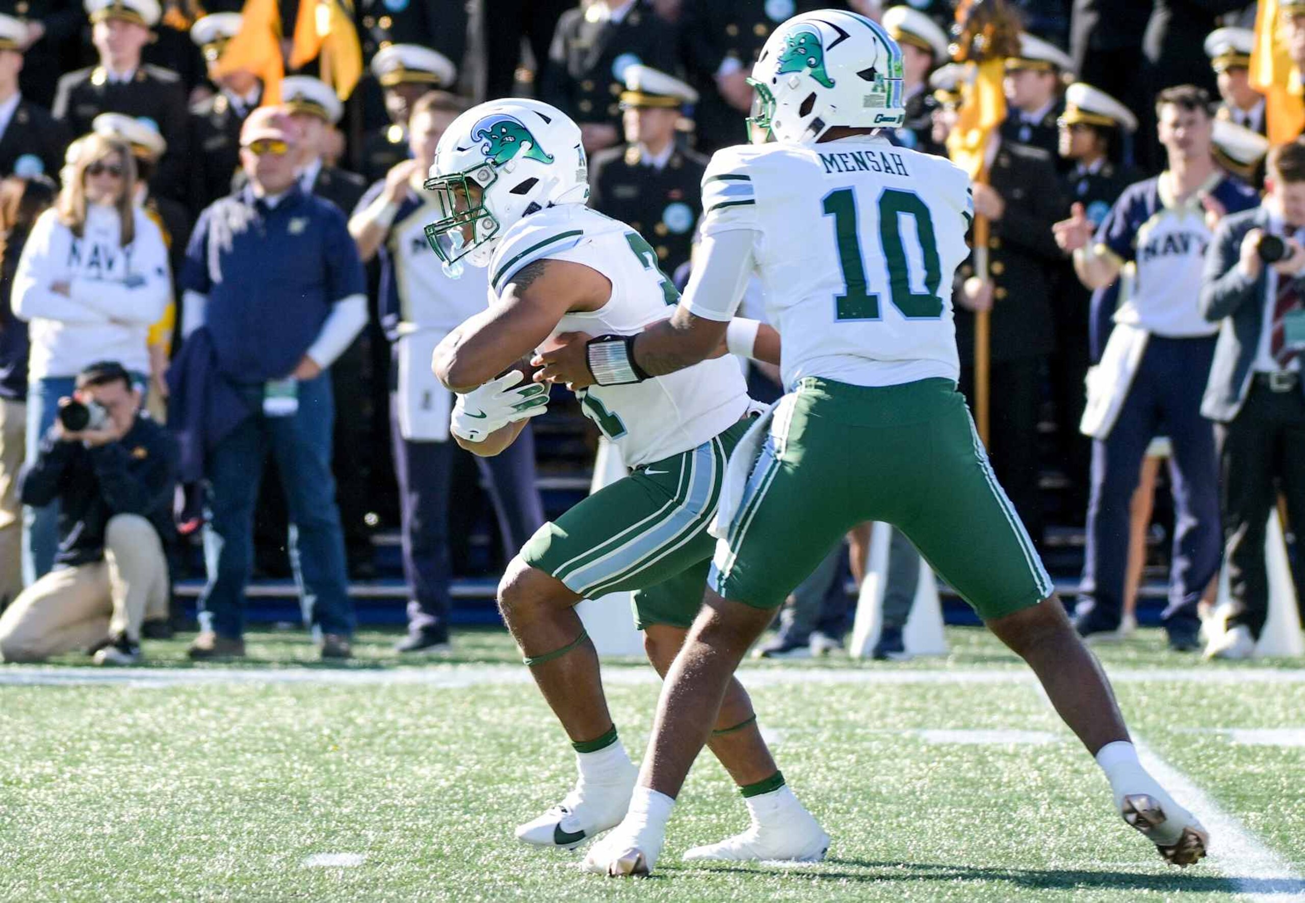 ANNAPOLIS, MD - NOVEMBER 16:  Tulane Green Wave running back Makhi Hughes (21) takes the hand off from quarterback Darian Mensah (10) during the Tulane Green Wave game versus the Naval Academy Midshipmen on November 16, 2024 at Navy - Marine Corps Memorial Stadium in Annapolis, MD. (Photo by Mark Goldman/Icon Sportswire via Getty Images)