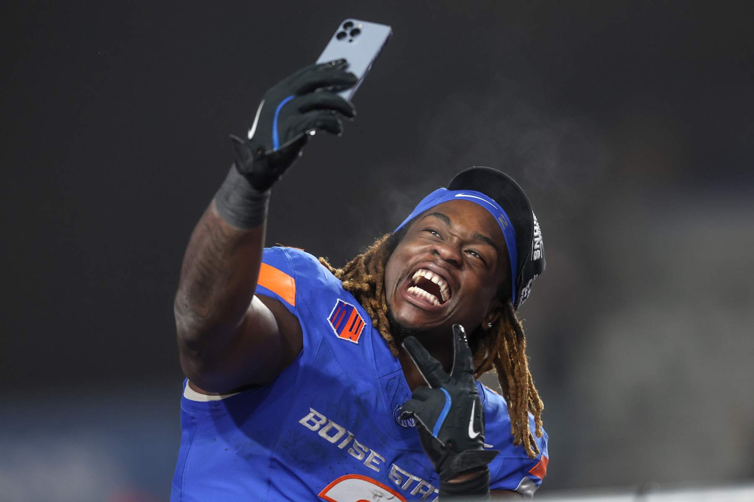BOISE, ID - DECEMBER 06: Running back Ashton Jeanty #2 of the Boise State Broncos celebrates a win and being named the offensive player of the game with a selfie at the conclusion of the second half of the Mountain West Championship against the UNLV Rebels at Albertsons Stadium on December 06, 2024 in Boise, Idaho. Boise State won the game 21-7. Jeanty moves into fourth place in FBS history for most rushing yards in a single season, 131 yards away from tying with Barry Sanders' 1988 single-season rushing record. (Photo by Loren Orr/Getty Images