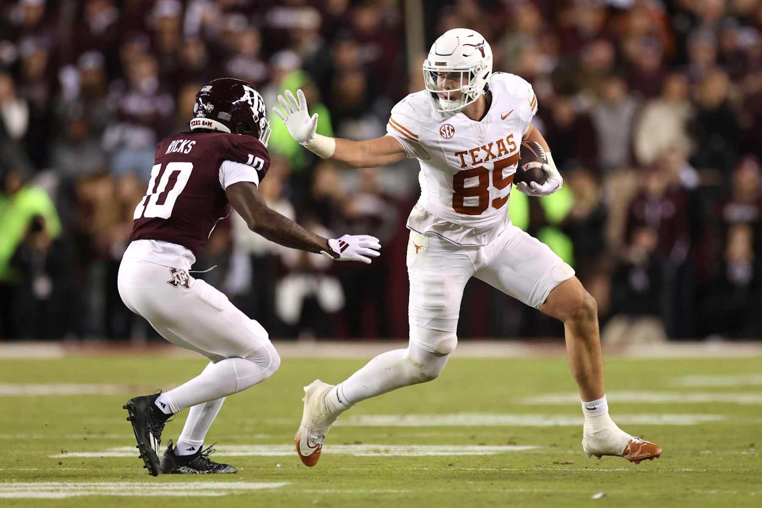 COLLEGE STATION, TEXAS - NOVEMBER 30: Gunnar Helm #85 of the Texas Longhorns gives a stiff arm to Dezz Ricks #10 of the Texas A&M Aggies during the third quarter at Kyle Field on November 30, 2024 in College Station, Texas. (Photo by Tim Warner/Getty Images)