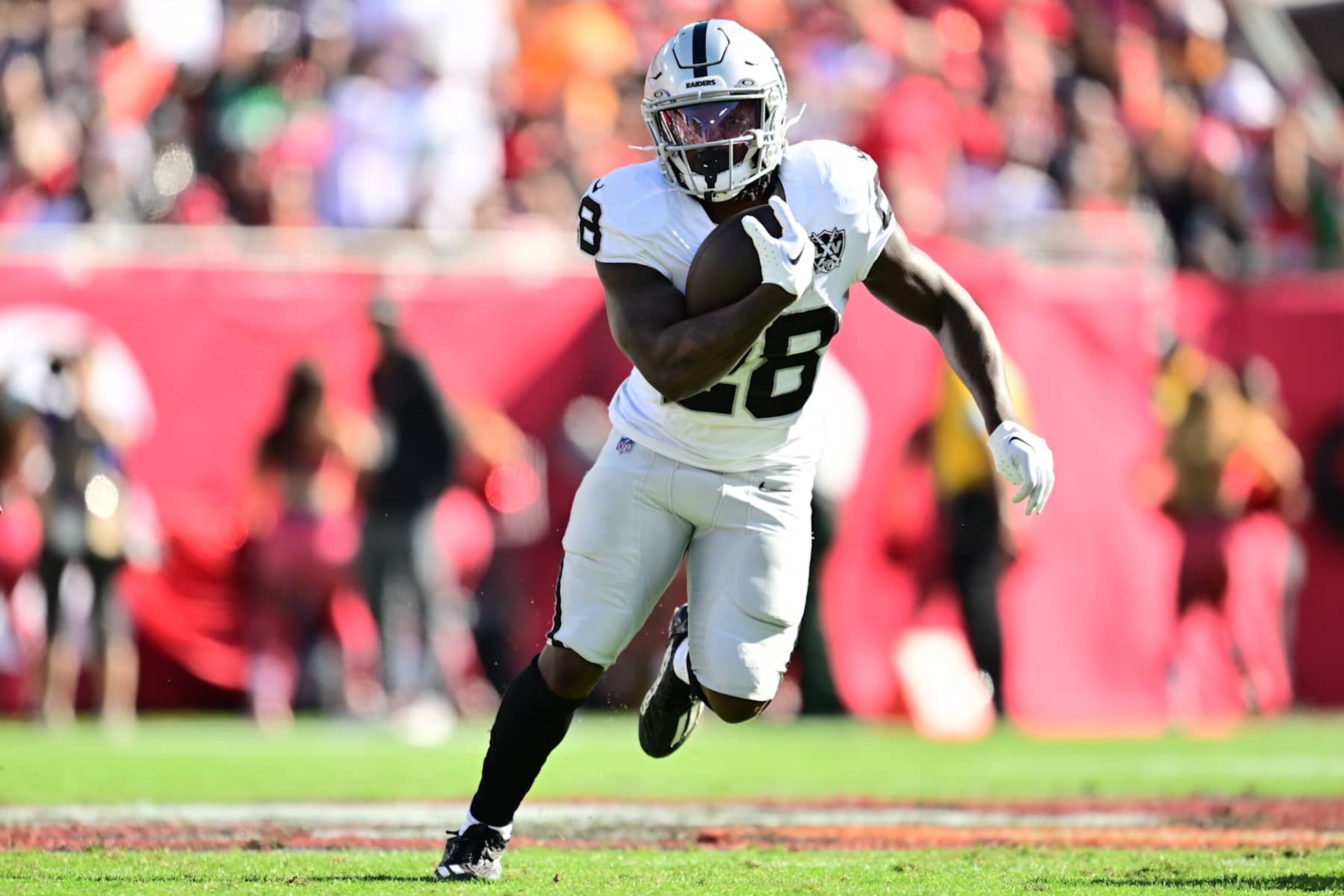 TAMPA, FLORIDA - DECEMBER 08: Sincere McCormick #28 of the Las Vegas Raiders runs with the ball during the second quarter against the Tampa Bay Buccaneers at Raymond James Stadium on December 08, 2024 in Tampa, Florida. (Photo by Julio Aguilar/Getty Images)