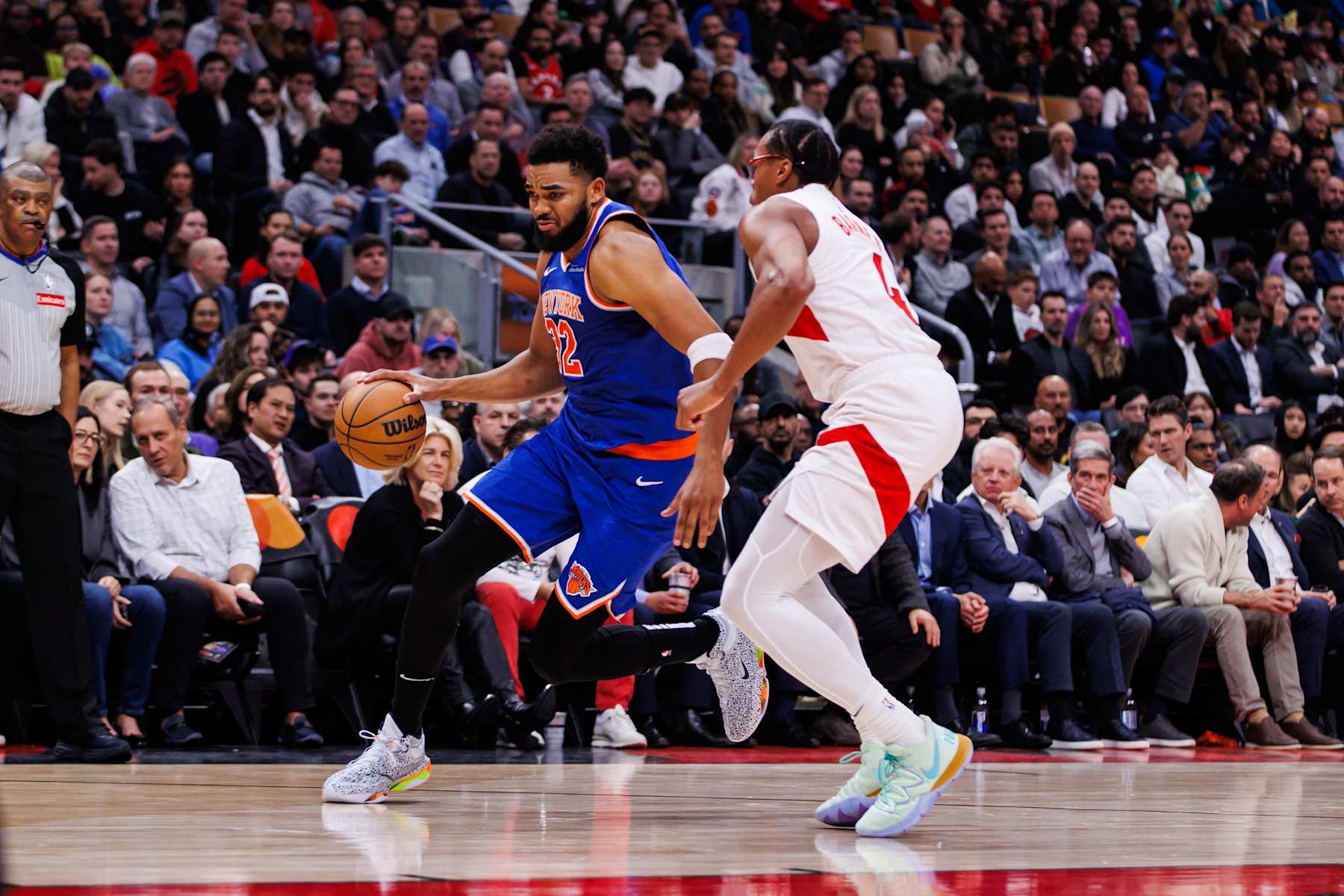 TORONTO, CANADA - DECEMBER 9: Karl-Anthony Towns #32 of the New York Knicks dribbles the ball against Scottie Barnes #4 of the Toronto Raptors during first half of their NBA game at Scotiabank Arena on December 9, 2024 in Toronto, Canada. NOTE TO USER: User expressly acknowledges and agrees that, by downloading and or using this photograph, User is consenting to the terms and conditions of the Getty Images License Agreement. (Photo by Cole Burston/Getty Images)
