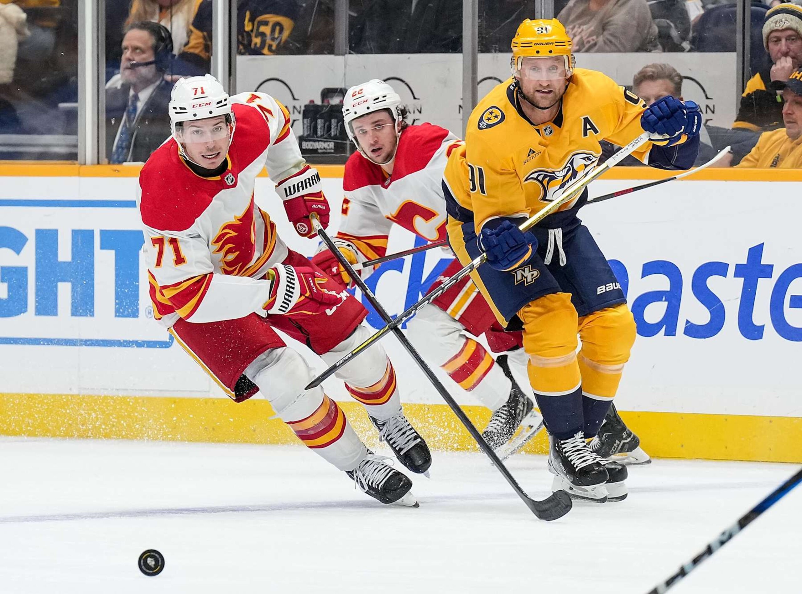 NASHVILLE, TENNESSEE - DECEMBER 10: Walker Duehr #71 of the Calgary Flames skates against Steven Stamkos #91 of the Nashville Predators during an NHL game at Bridgestone Arena on December 10, 2024 in Nashville, Tennessee. (Photo by John Russell/NHLI via Getty Images) NASHVILLE, TENNESSEE - DECEMBER 10: Walker Duehr #71 of the Calgary Flames skates against Steven Stamkos #91 of the Nashville Predators during an NHL game at Bridgestone Arena on December 10, 2024 in Nashville, Tennessee. (Photo by John Russell/NHLI via Getty Images)