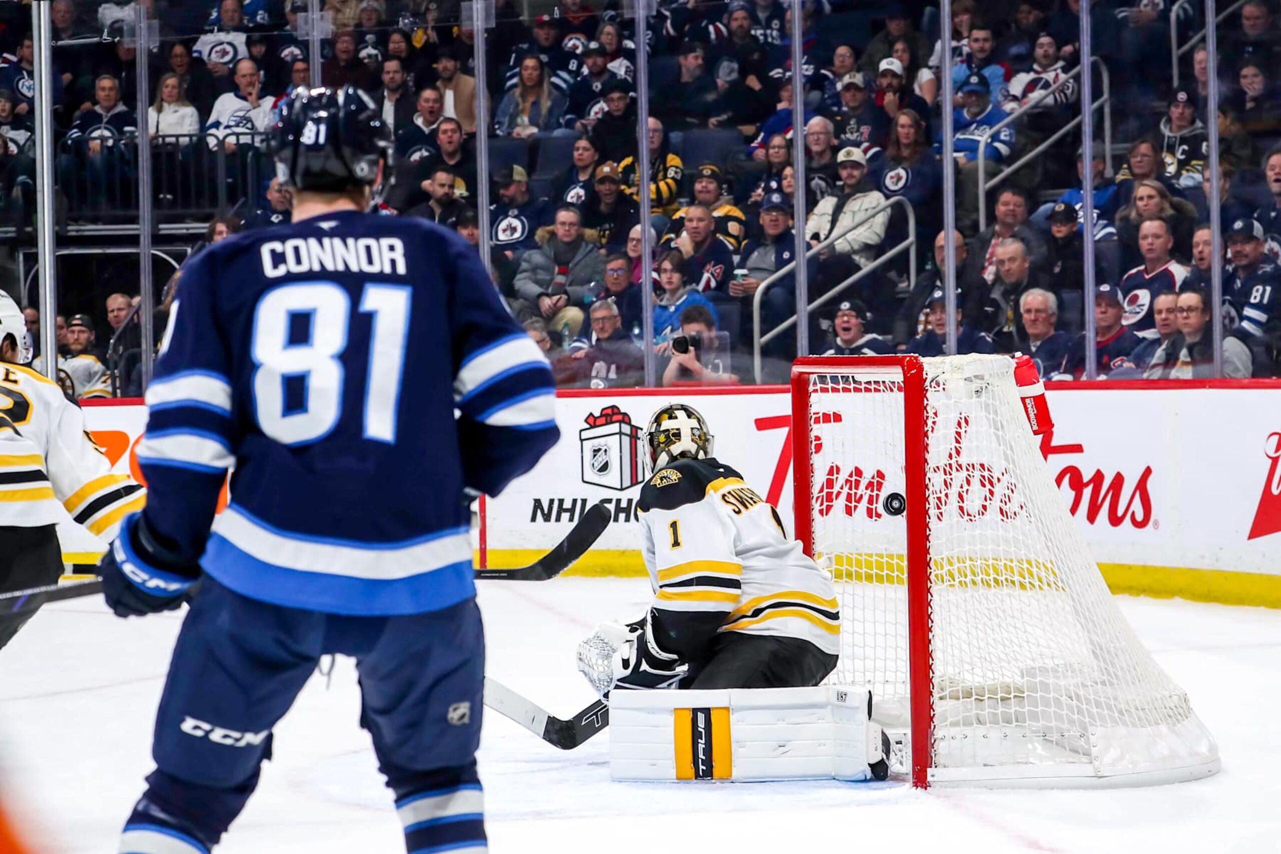 WINNIPEG, CANADA - DECEMBER 10: Kyle Connor #81 of the Winnipeg Jets watches as a shot by teammate Mark Scheifele #55 (not seen) gets behind goaltender Jeremy Swayman #1 of the Boston Bruins for a first period goal at the Canada Life Centre on December 10, 2024 in Winnipeg, Manitoba, Canada. (Photo by Darcy Finley/NHLI via Getty Images) WINNIPEG, CANADA - DECEMBER 10: Kyle Connor #81 of the Winnipeg Jets watches as a shot by teammate Mark Scheifele #55 (not seen) gets behind goaltender Jeremy Swayman #1 of the Boston Bruins for a first period goal at the Canada Life Centre on December 10, 2024 in Winnipeg, Manitoba, Canada. (Photo by Darcy Finley/NHLI via Getty Images)