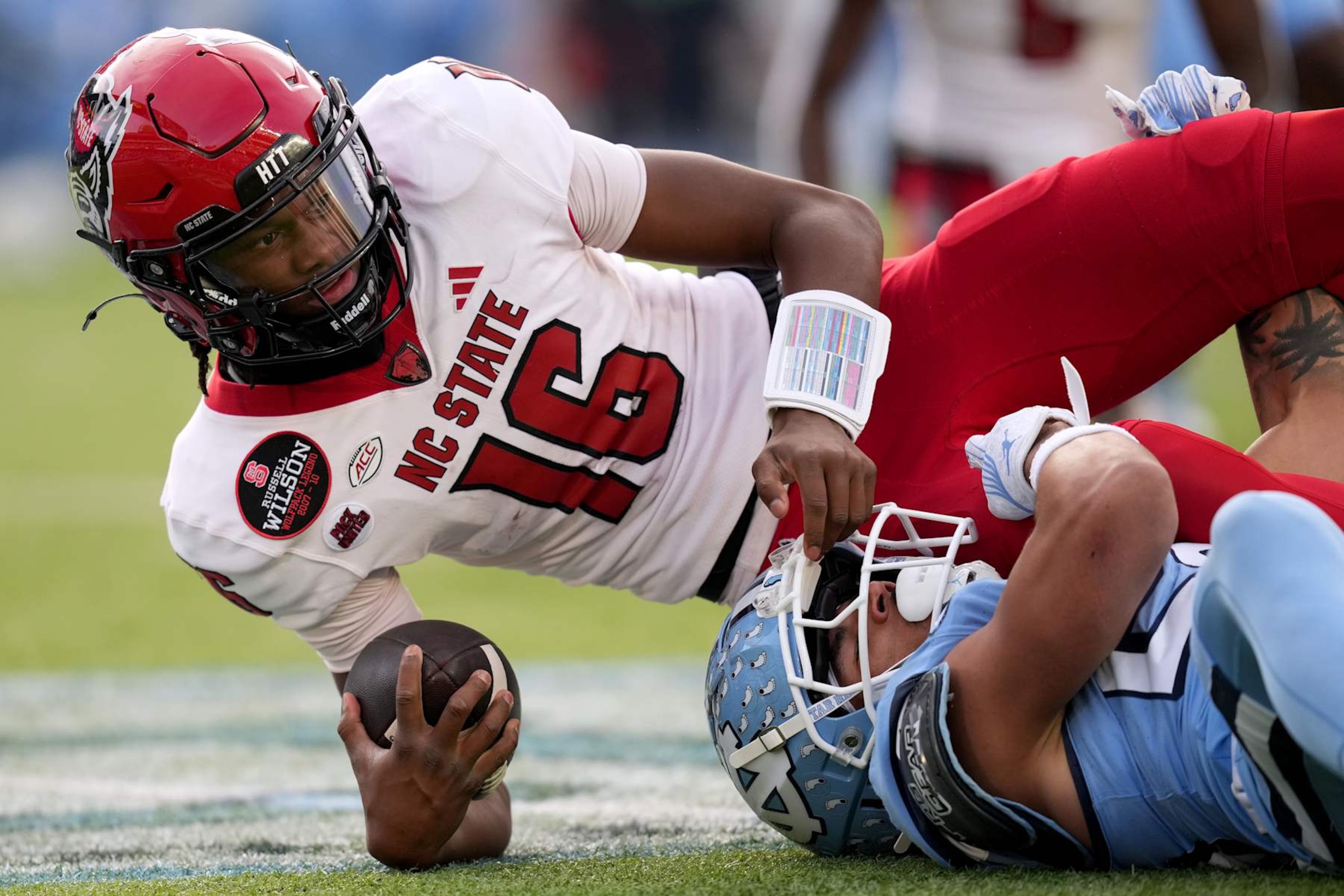CHAPEL HILL, NORTH CAROLINA - NOVEMBER 30: Alijah Huzzie #28 of the North Carolina Tar Heels tackles CJ Bailey #16 of the North Carolina State Wolfpack during the first half of the game at Kenan Memorial Stadium on November 30, 2024 in Chapel Hill, North Carolina. (Photo by Grant Halverson/Getty Images)