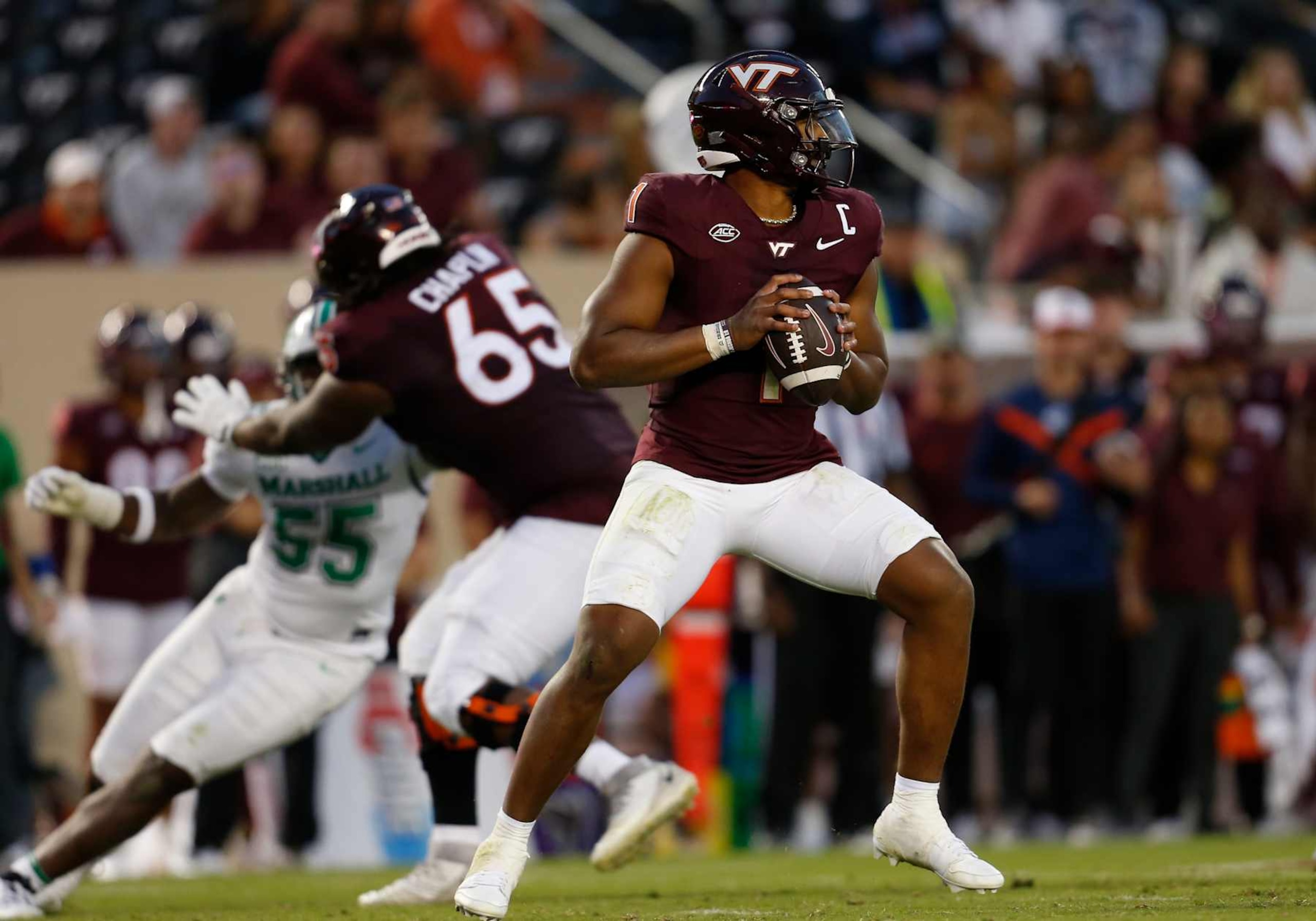 BLACKSBURG, VA - SEPTEMBER 07: Virginia Tech Hokies quarterback Kyron Drones (1) surveys the field for an open receiver from the pocket while Hokies offensive lineman Xavier Chaplin (65) attempts to block Marshall Thundering Herd defensive lineman J.J. Hawkins (55) during a college football game between the Marshall Thundering Herd and the Virginia Tech Hokies on September 7, 2024, at Lane Stadium in Blacksburg, VA. (Photo by Lee Coleman/Icon Sportswire via Getty Images)