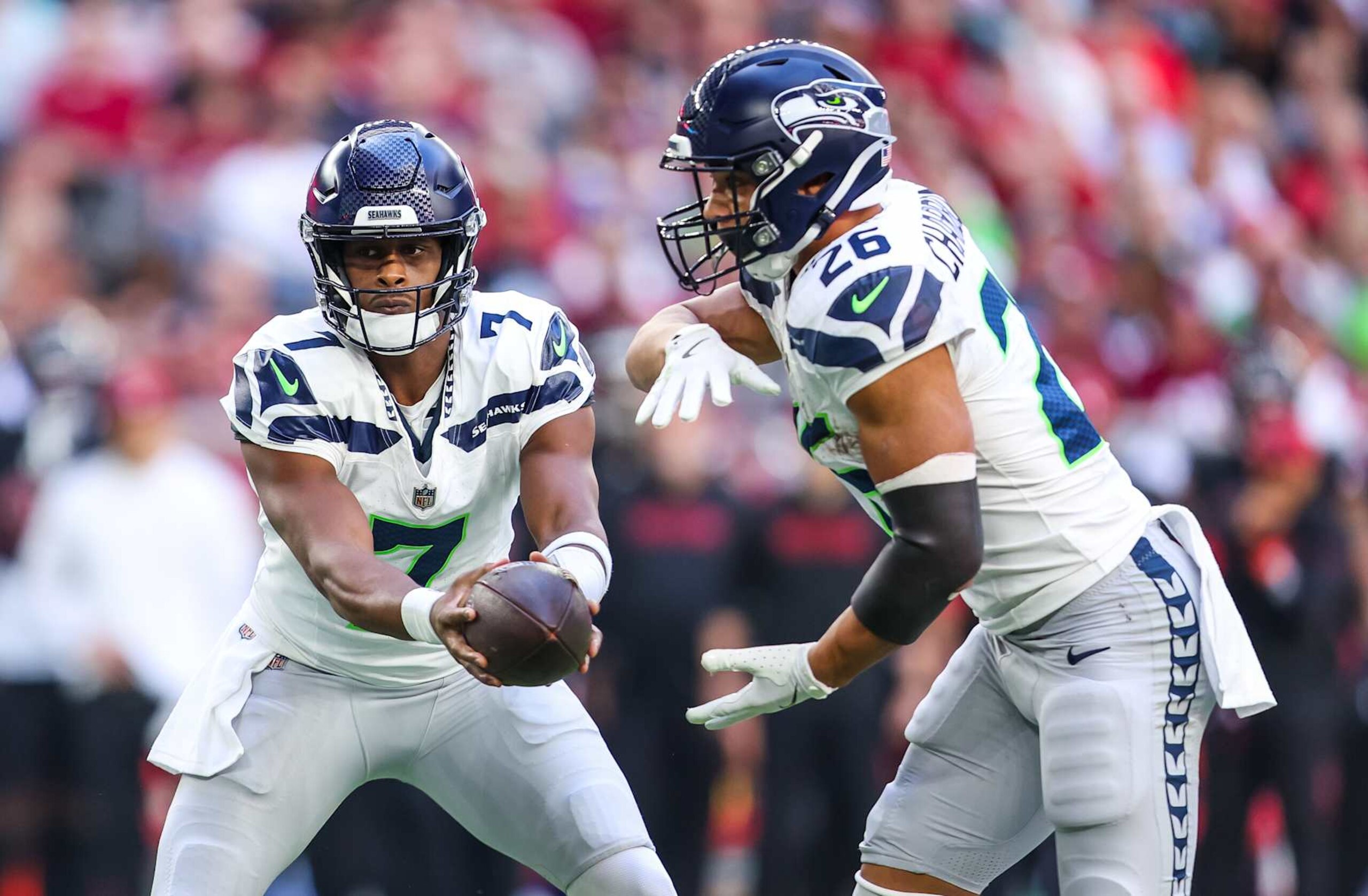 GLENDALE, ARIZONA - DECEMBER 8: Geno Smith #7 of the Seattle Seahawks hands the ball off to Zach Charbonnet #26 during the first quarter of a game against the Arizona Cardinals at State Farm Stadium on December 8, 2024 in Glendale, Arizona. (Photo by Mike Christy/Getty Images)