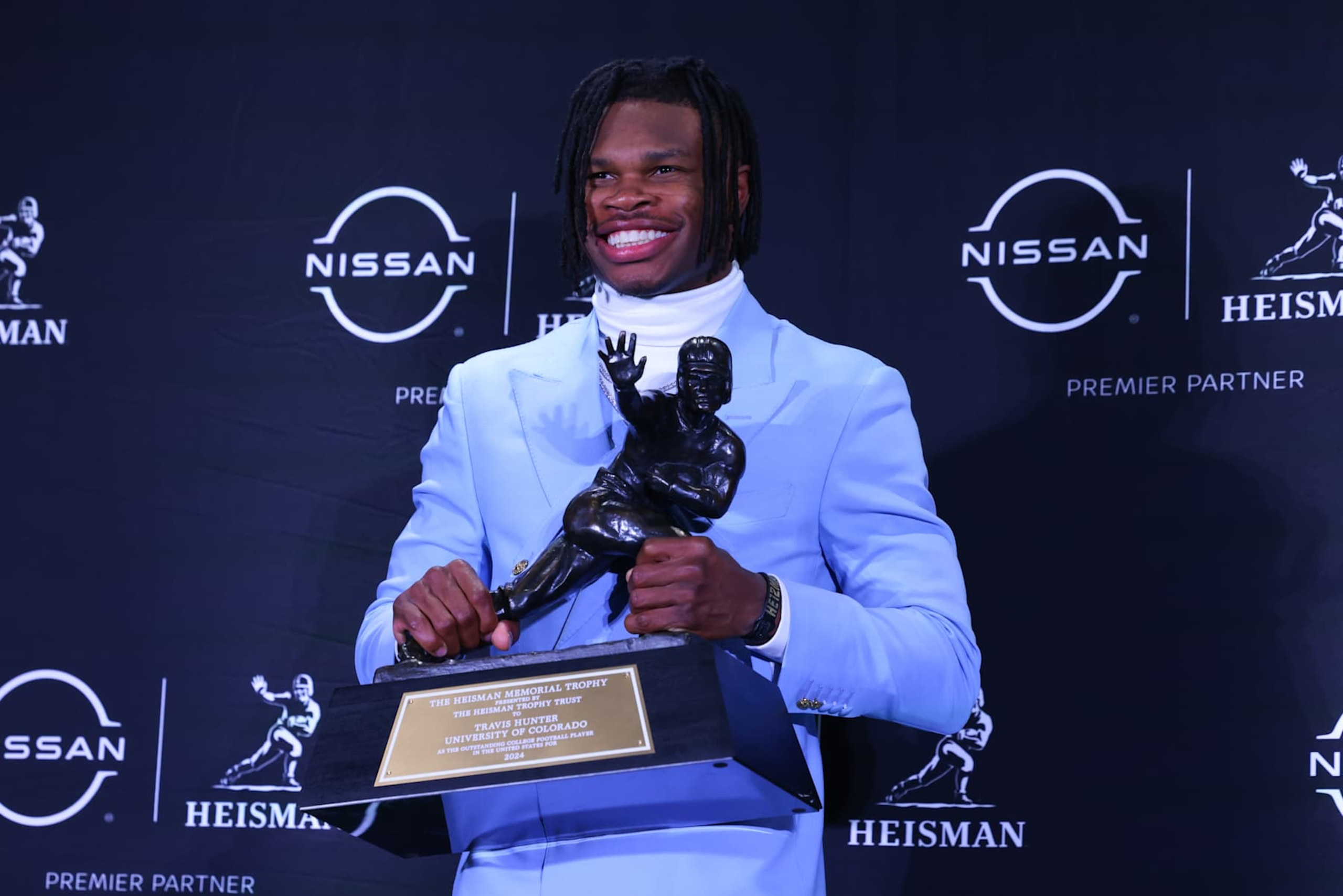 NEW YORK, NY - DECEMBER 14: Travis Hunter University of Colorado cornerback/wide receiver poses with the Trophy during the Heisman Trophy press conference at the Marriott Marquis on December 14, 2024 in New York, New York. (Photo by Rich Graessle/Icon Sportswire via Getty Images) NEW YORK, NY - DECEMBER 14: Travis Hunter University of Colorado cornerback/wide receiver poses with the Trophy during the Heisman Trophy press conference at the Marriott Marquis on December 14, 2024 in New York, New York. (Photo by Rich Graessle/Icon Sportswire via Getty Images)