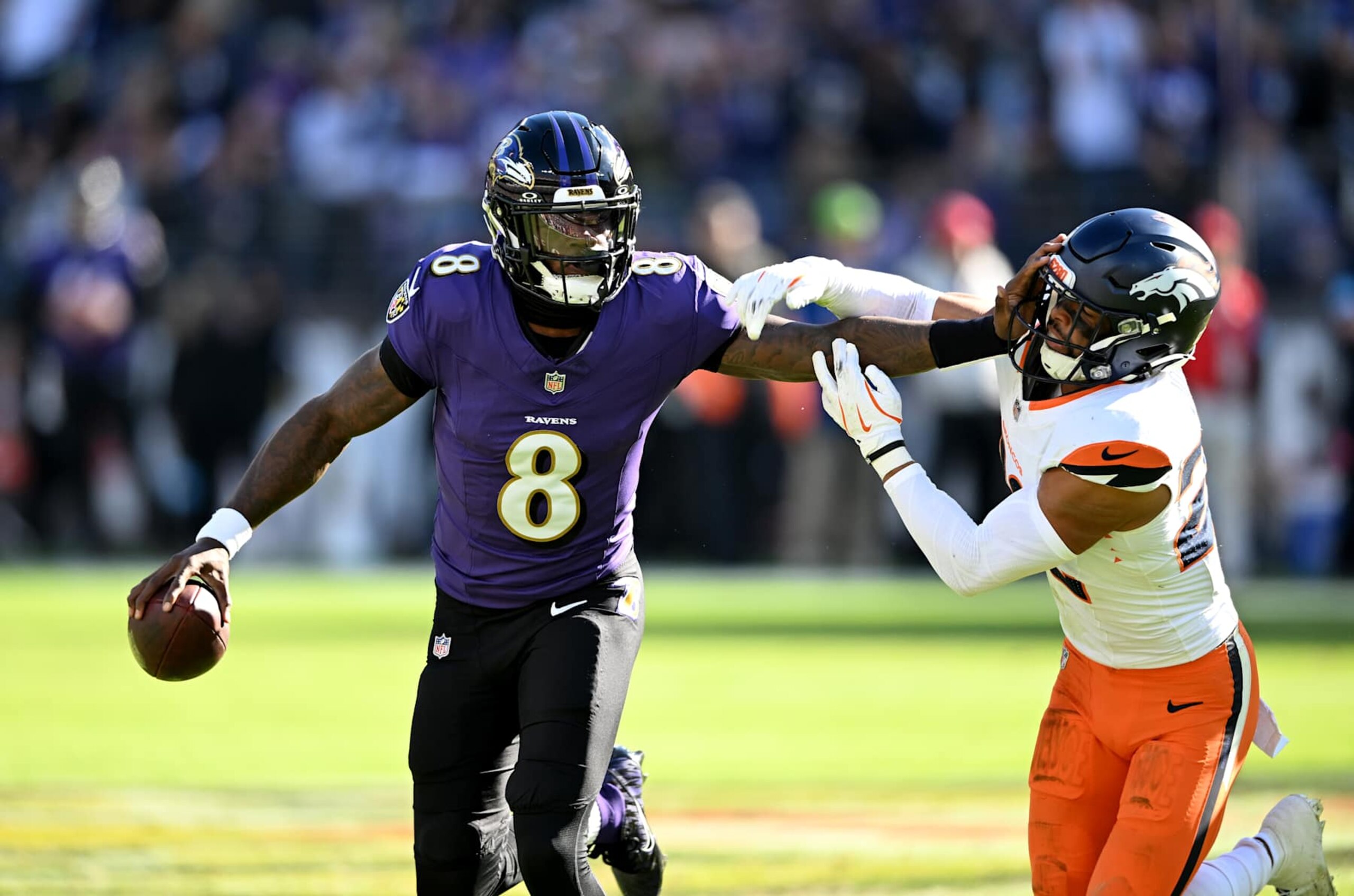BALTIMORE, MARYLAND - NOVEMBER 03: Lamar Jackson #8 of the Baltimore Ravens drops back to pass against Brandon Jones #22 of the Denver Broncos at M&T Bank Stadium on November 03, 2024 in Baltimore, Maryland. (Photo by G Fiume/Getty Images)