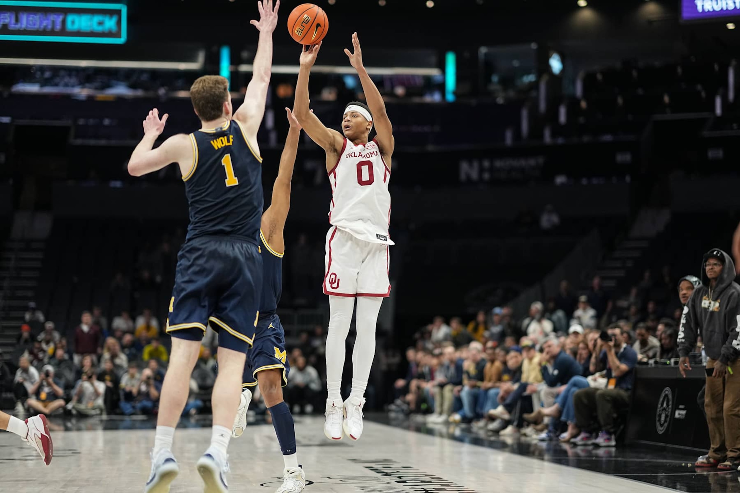 CHARLOTTE, NORTH CAROLINA - DECEMBER 18: Jeremiah Fears #0 of the Oklahoma Sooners makes a three point basket over Danny Wolf #1 and Roddy Gayle Jr. #11 of the Michigan Wolverines in the second half of their game during the Jumpman Invitational at Spectrum Center on December 18, 2024 in Charlotte, North Carolina. (Photo by Matt Kelley/Getty Images)