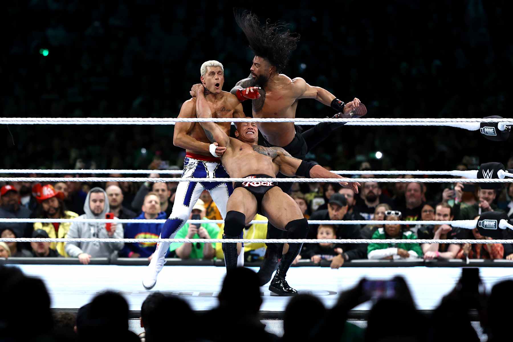 PHILADELPHIA, PENNSYLVANIA - APRIL 06: Cody Rhodes is hit by Dwayne "The Rock" Johnson and Roman Reigns during a fight during Night One of WrestleMania 40 at Lincoln Financial Field on April 06, 2024 in Philadelphia, Pennsylvania.  (Photo by Tim Nwachukwu/Getty Images)