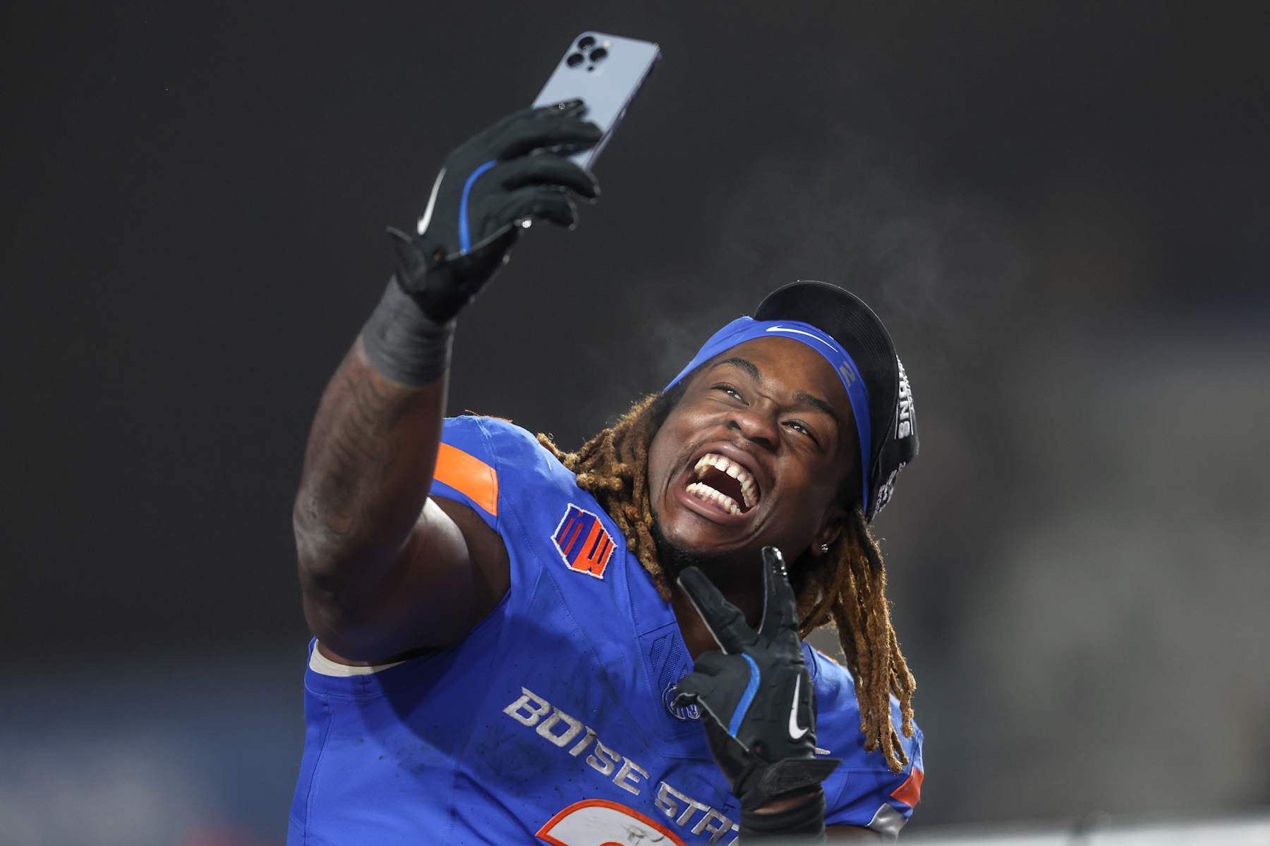 BOISE, ID - DECEMBER 06: Running back Ashton Jeanty #2 of the Boise State Broncos celebrates a win and being named the offensive player of the game with a selfie at the conclusion of the second half of the Mountain West Championship against the UNLV Rebels at Albertsons Stadium on December 06, 2024 in Boise, Idaho. Boise State won the game 21-7. Jeanty moves into fourth place in FBS history for most rushing yards in a single season, 131 yards away from tying with Barry Sanders' 1988 single-season rushing record. (Photo by Loren Orr/Getty Images