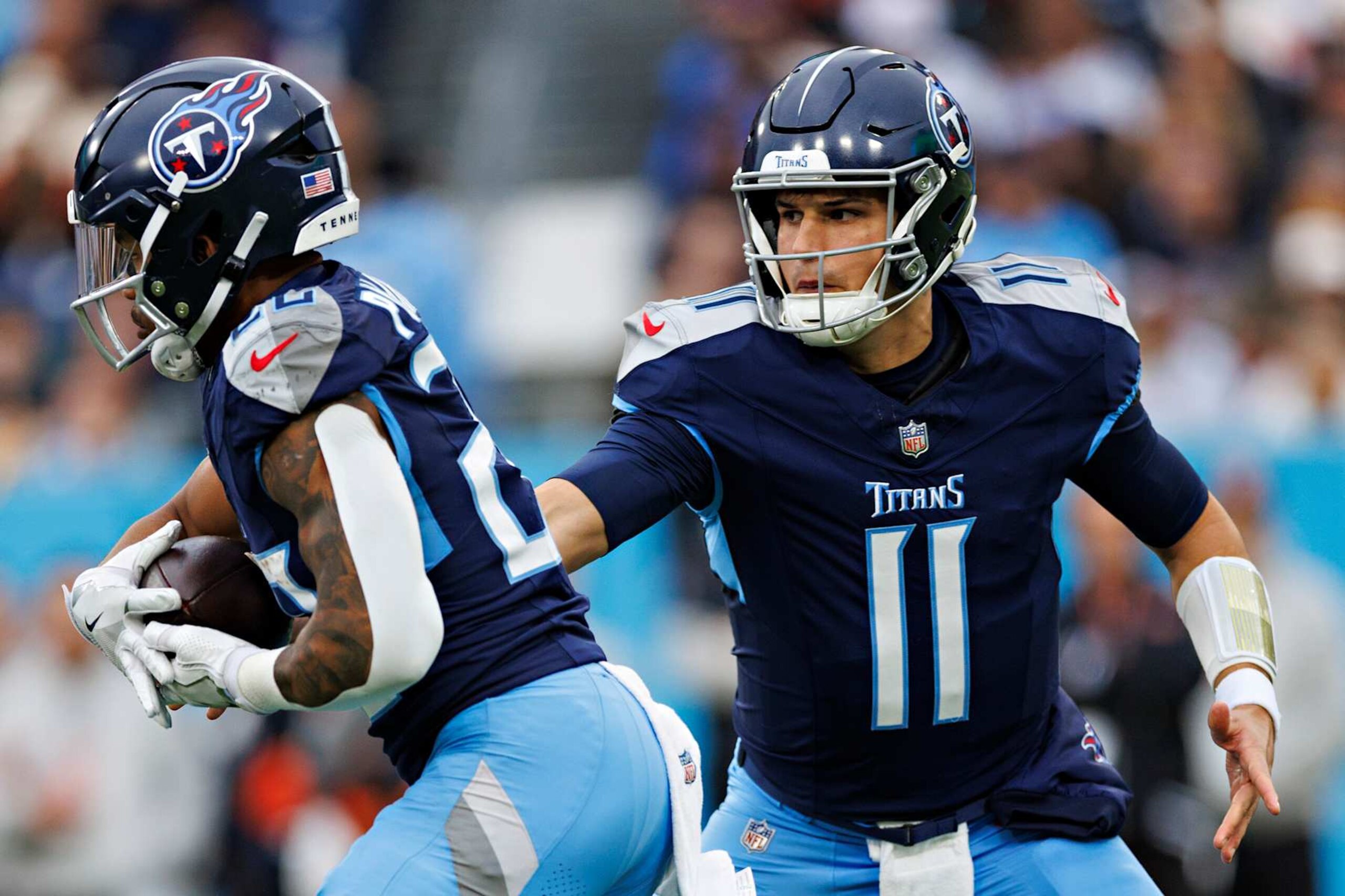 NASHVILLE, TENNESSEE - DECEMBER 15: Mason Rudolph #11 hands off the ball to Tony Pollard #20 of the Tennessee Titans during a game against the Cincinnati Bengals at Nissan Stadium on December 15, 2024 in Nashville, Tennessee. The Bengals defeated the Titans 37-27.  (Photo by Wesley Hitt/Getty Images)