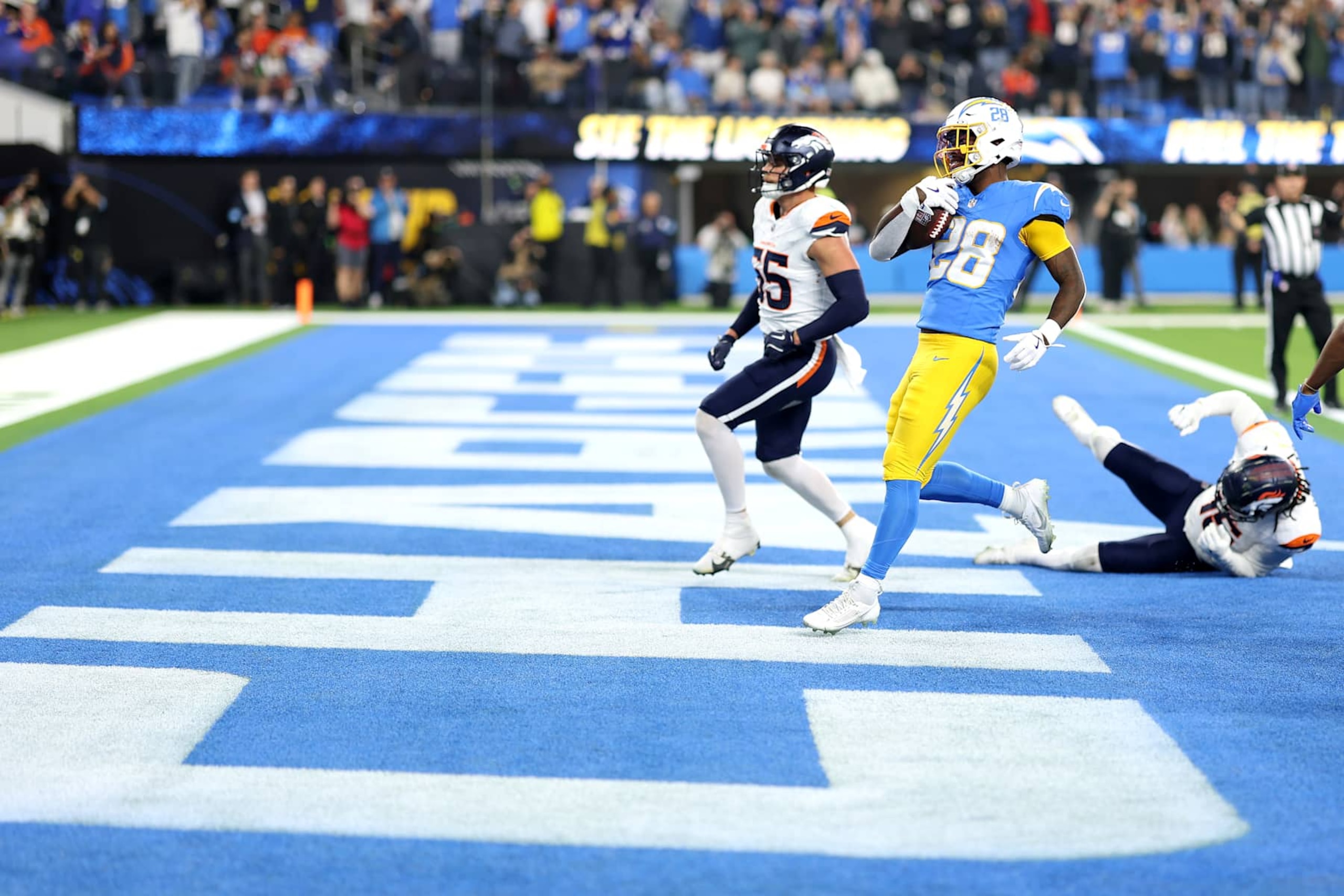 INGLEWOOD, CALIFORNIA - DECEMBER 19: Hassan Haskins #28 of the Los Angeles Chargers scores a touchdown against Cody Barton #55 and Nik Bonitto #15 of the Denver Broncos during the fourth quarter in the game at SoFi Stadium on December 19, 2024 in Inglewood, California. (Photo by Sean M. Haffey/Getty Images)