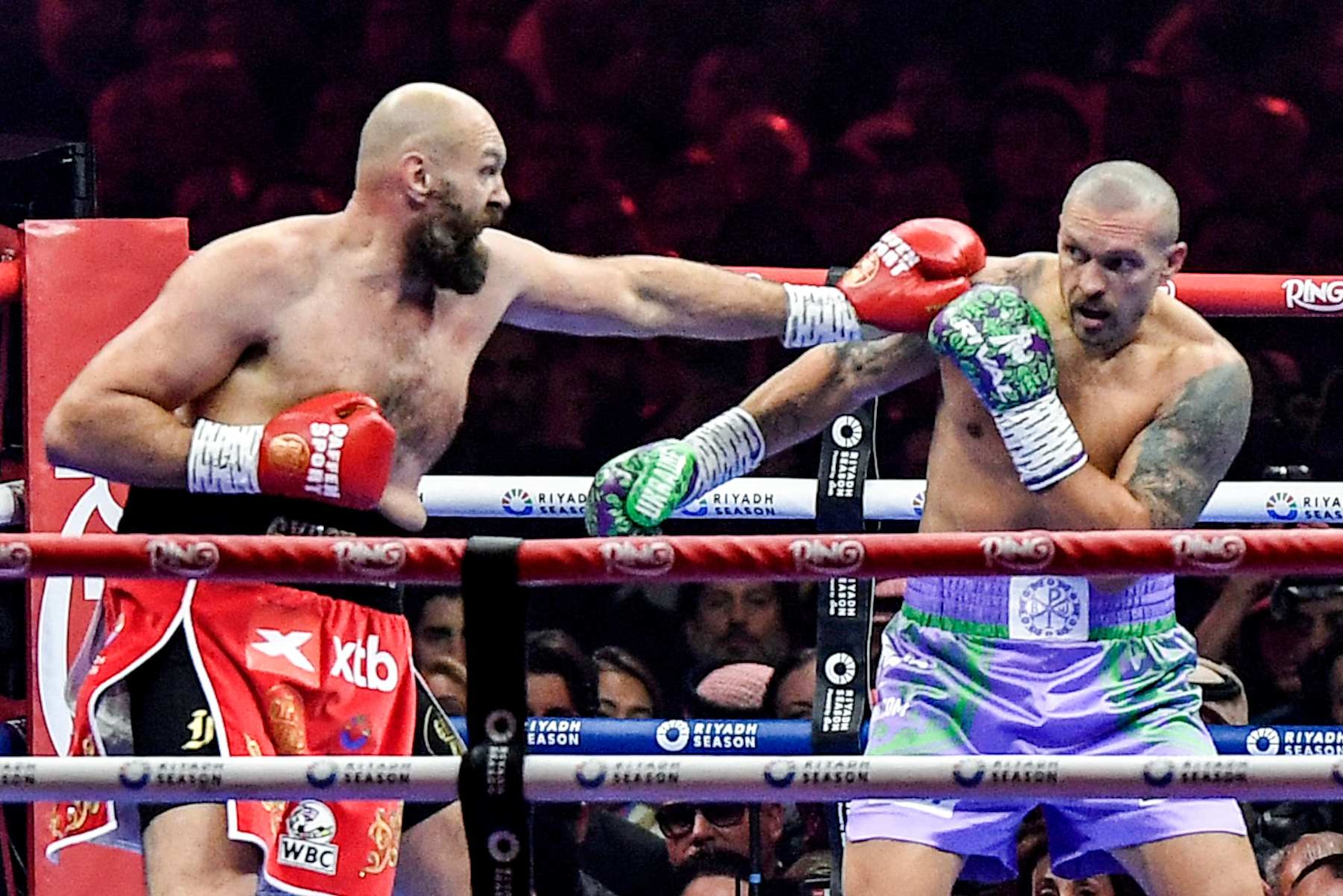 Britain's Tyson Fury (red) and Ukraine's Oleksandr Usyk (blue) compete during their heavyweight world championship rematch at the Kingdom Arena in Riyadh on December 22, 2024. (Photo by AFP) (Photo by -/AFP via Getty Images)