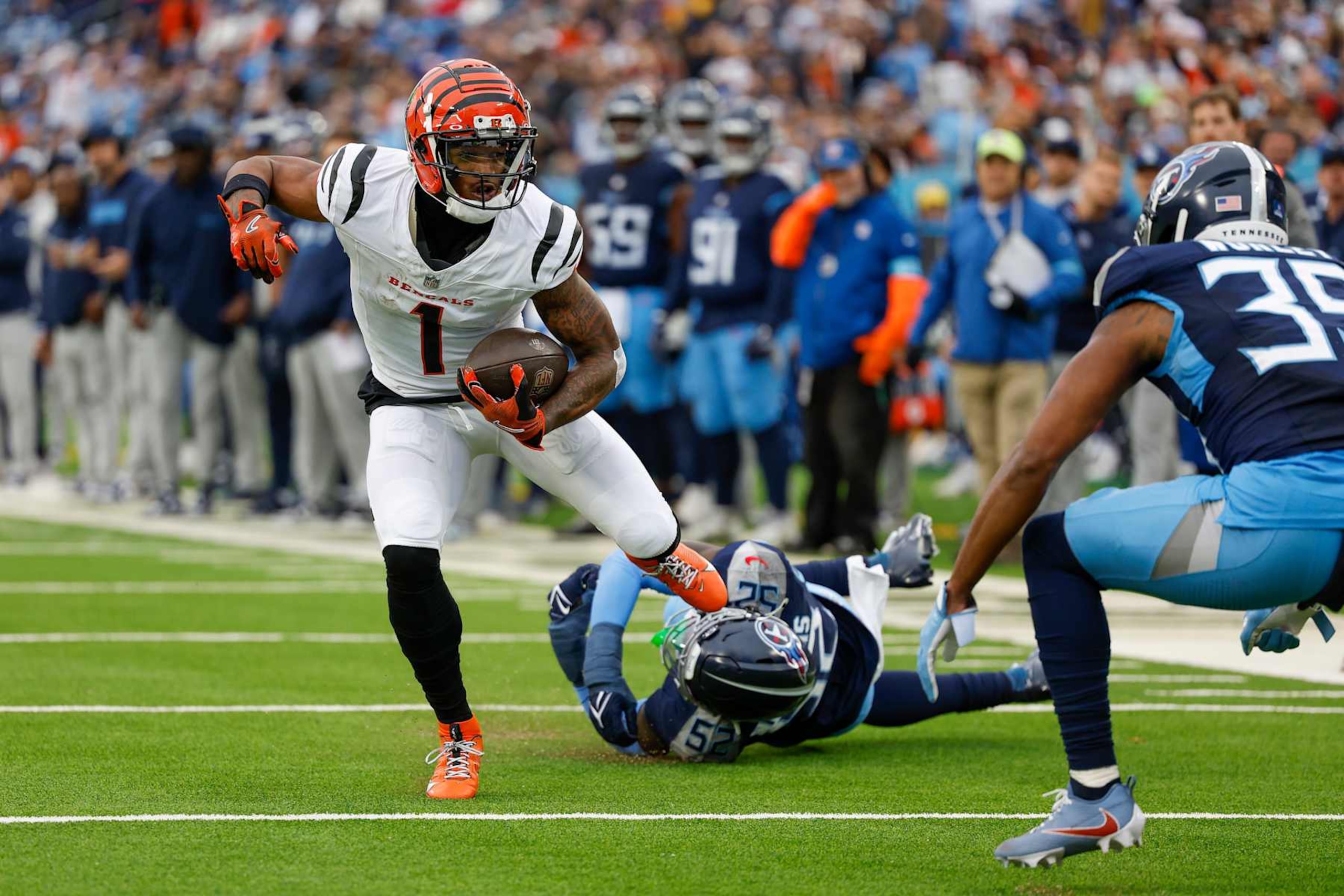 NASHVILLE, TENNESSEE - DECEMBER 15: Ja'Marr Chase #1 of the Cincinnati Bengals breaks a tackle by James Williams #52 of the Tennessee Titans in the second quarter at Nissan Stadium on December 15, 2024 in Nashville, Tennessee. (Photo by Wesley Hitt/Getty Images)