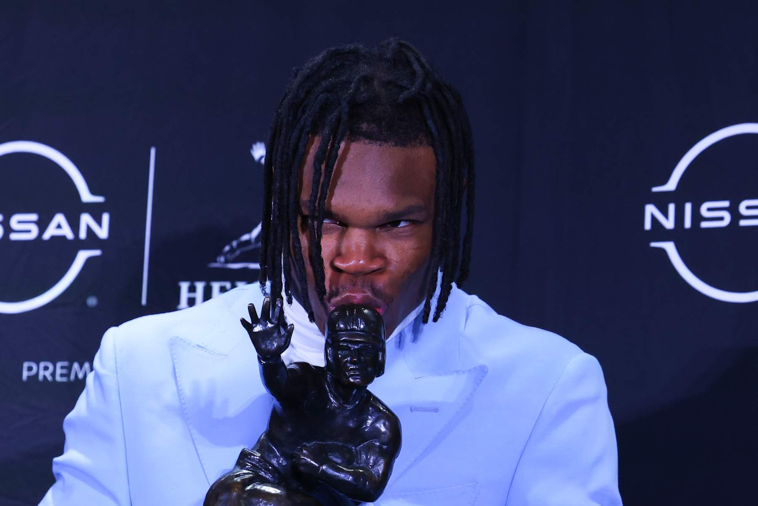 NEW YORK, NY - DECEMBER 14:  Travis Hunter University of Colorado cornerback/wide receiver kisses the Trophy during the Heisman Trophy press conference at the Marriott Marquis on December 14, 2024 in New York, New York. (Photo by Rich Graessle/Icon Sportswire via Getty Images)