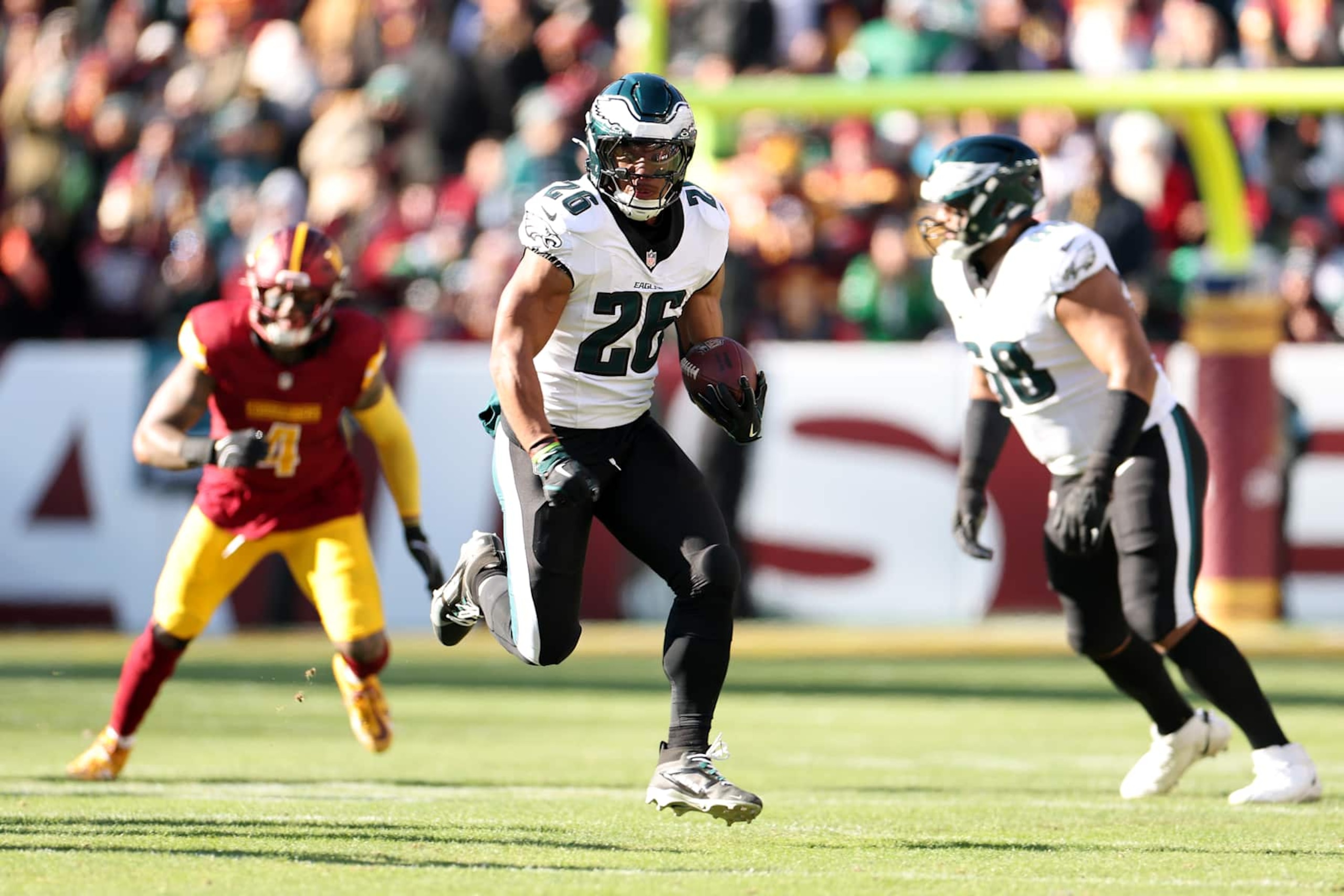 LANDOVER, MARYLAND - DECEMBER 22:  Saquon Barkley #26 of the Philadelphia Eagles runs the ball against the Washington Commanders during the first quarter at Northwest Stadium on December 22, 2024 in Landover, Maryland. (Photo by Scott Taetsch/Getty Images)