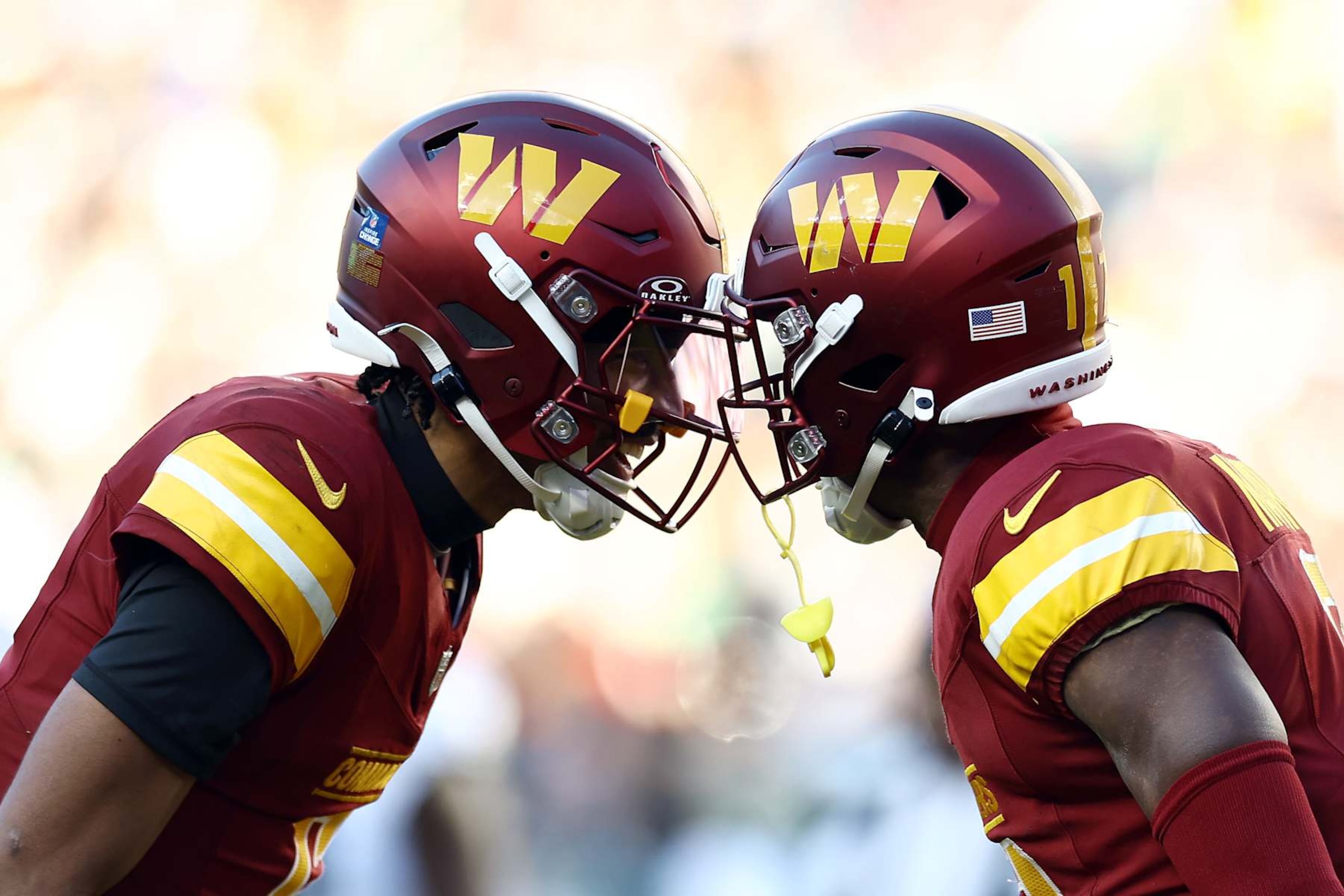 LANDOVER, MARYLAND - DECEMBER 22:  Jayden Daniels #5 is congratulated by Jeremy Chinn #11 of the Washington Commanders after a touchdown pass against the Philadelphia Eagles during the second quarter at Northwest Stadium on December 22, 2024 in Landover, Maryland. (Photo by Timothy Nwachukwu/Getty Images)