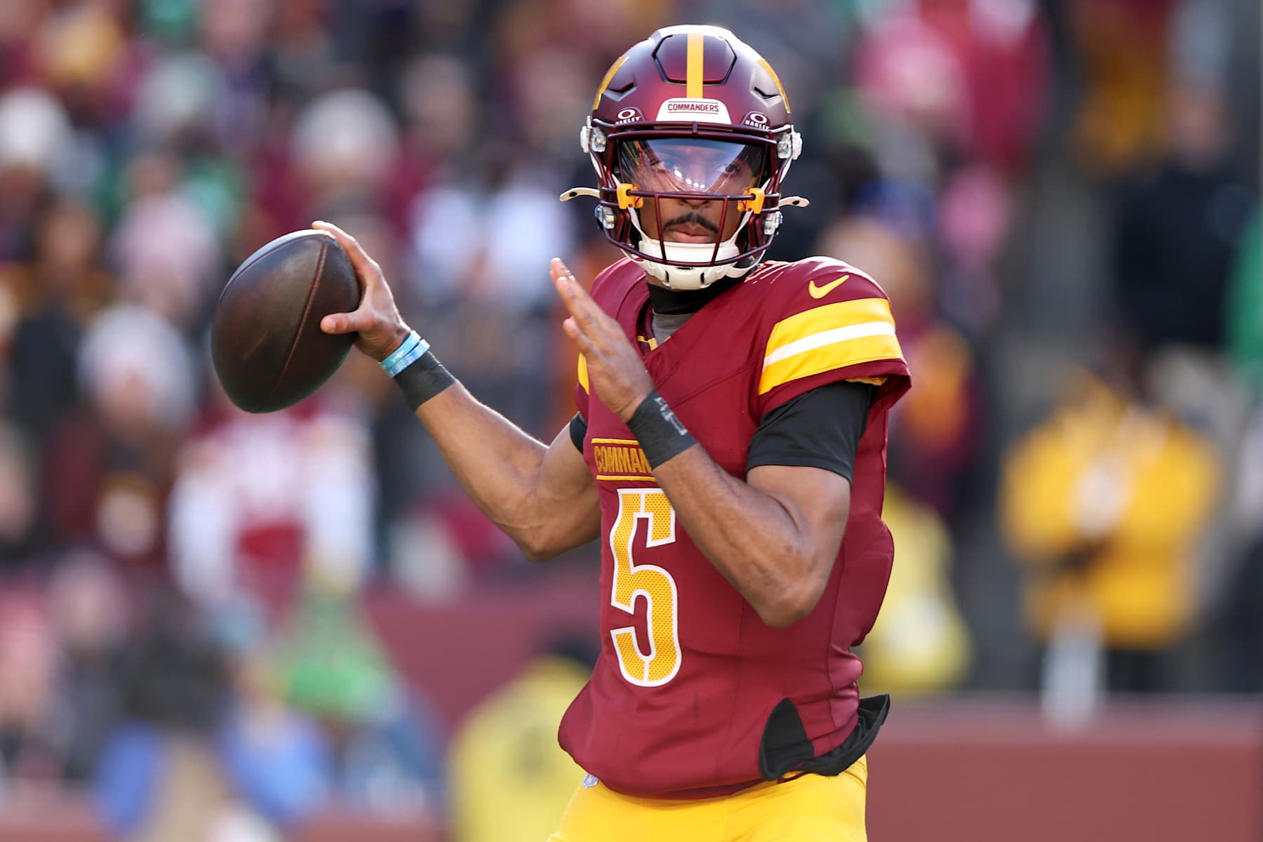 LANDOVER, MARYLAND - DECEMBER 22:  Jayden Daniels #5 of the Washington Commanders attempts a pass against the Philadelphia Eagles during the first quarter at Northwest Stadium on December 22, 2024 in Landover, Maryland. (Photo by Scott Taetsch/Getty Images)