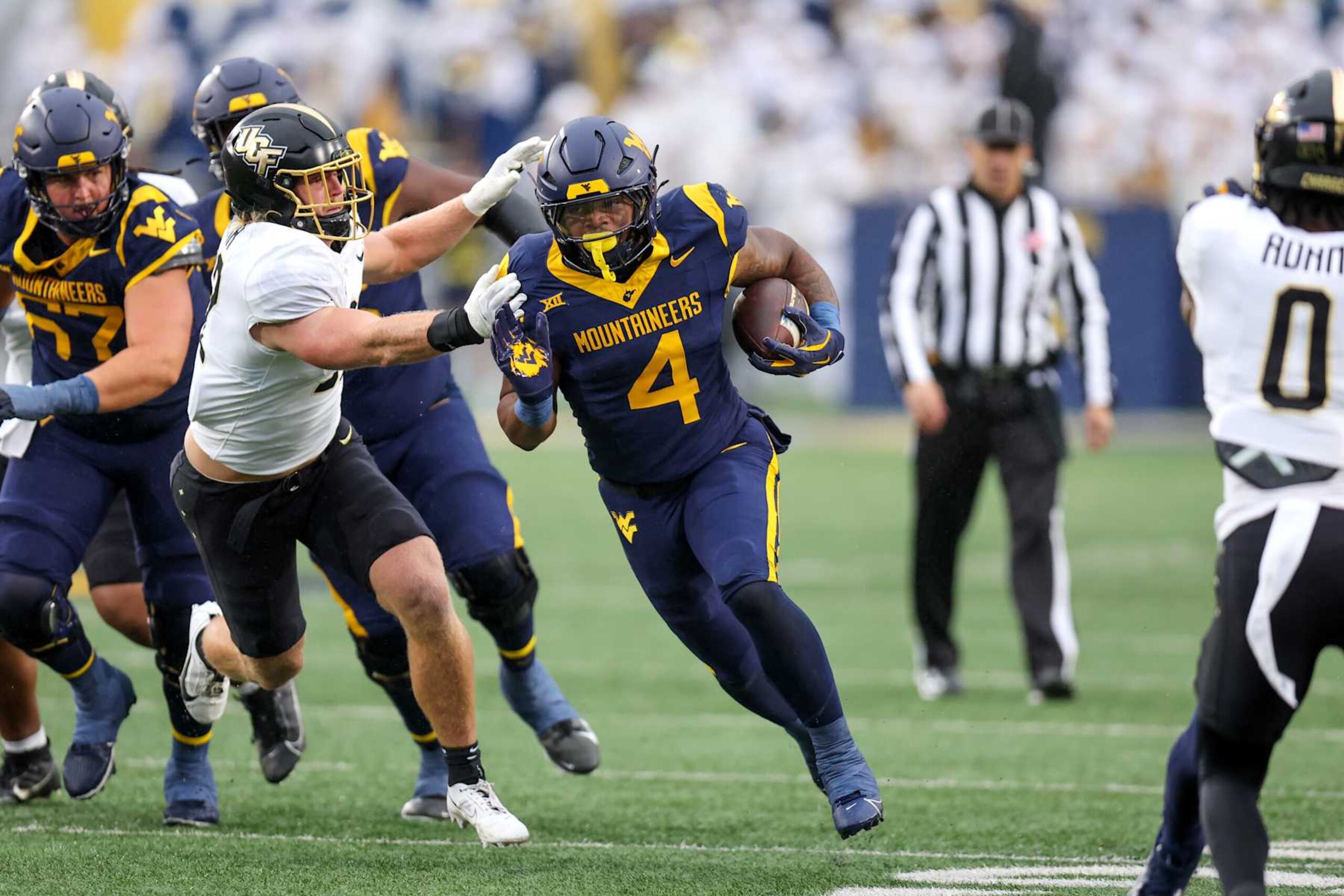 MORGANTOWN, WV - NOVEMBER 23: West Virginia Mountaineers running back CJ Donaldson Jr. (4) carries the football during the first quarter of the college football game between UCF Knights and the West Virginia Mountaineers on November 23, 2024, at Mountaineer Field at Milan Puskar Stadium in Morgantown, WV. (Photo by Frank Jansky/Icon Sportswire via Getty Images)