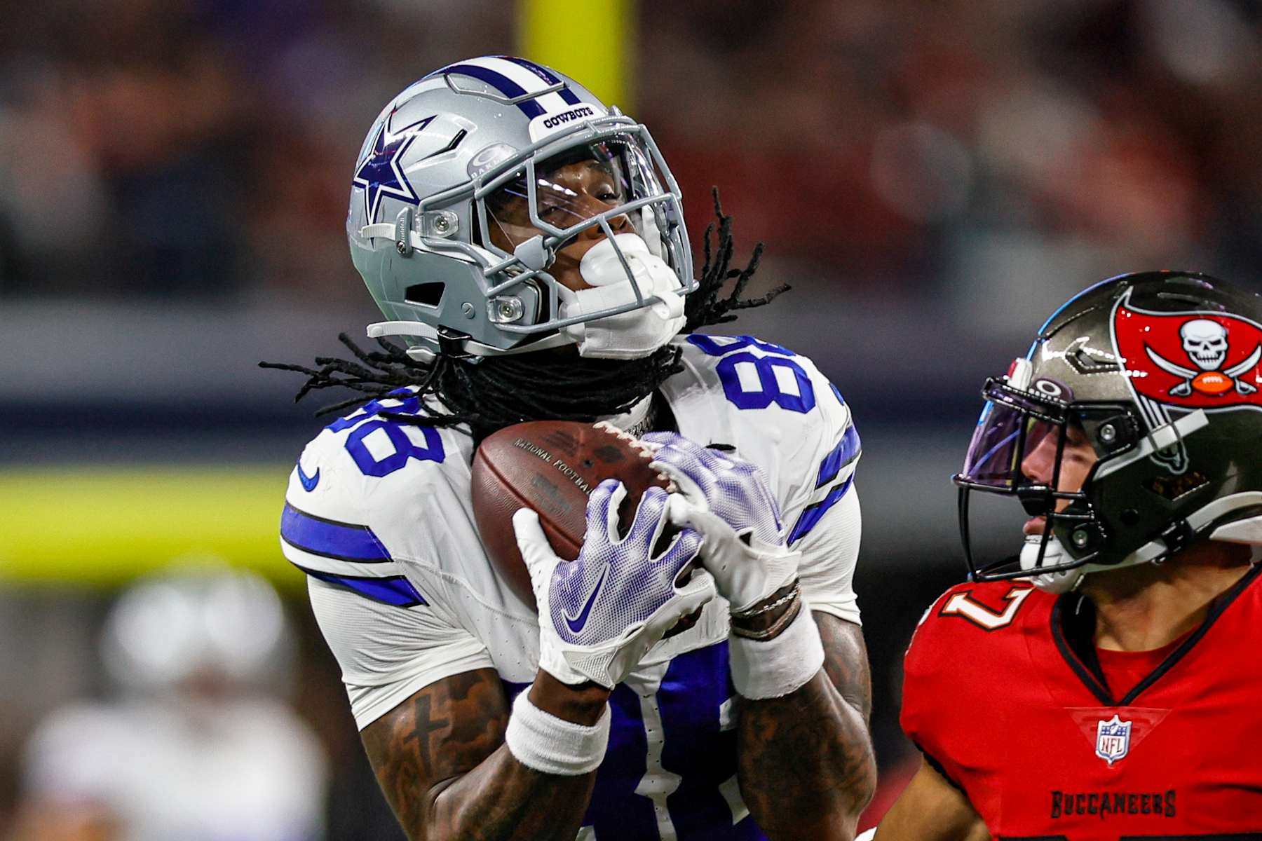ARLINGTON, TX - DECEMBER 22: Dallas Cowboys wide receiver CeeDee Lamb (88) catches a pass over Tampa Bay Buccaneers cornerback Zyon McCollum (27) during the game between the Dallas Cowboys and the Tampa Bay Buccaneers on December 22, 2024 at AT&T Stadium in Arlington, Texas. (Photo by Matthew Pearce/Icon Sportswire via Getty Images)