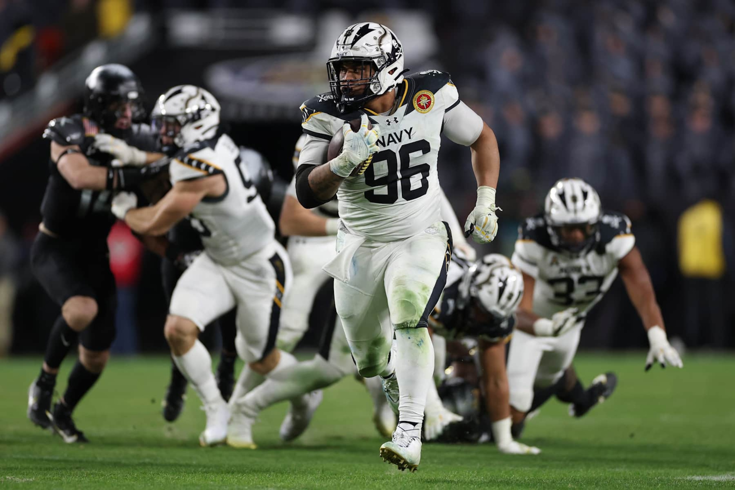 LANDOVER, MARYLAND - DECEMBER 14: Landon Robinson #96 of the Navy Midshipmen rushes wit h the ball on a fake punk against the Army Black Knights during the first half of 125th America's Game between the Army Black Knights and the Navy Midshipmen at Northwest Stadium on December 14, 2024 in Landover, Maryland.  (Photo by Patrick Smith/Getty Images)