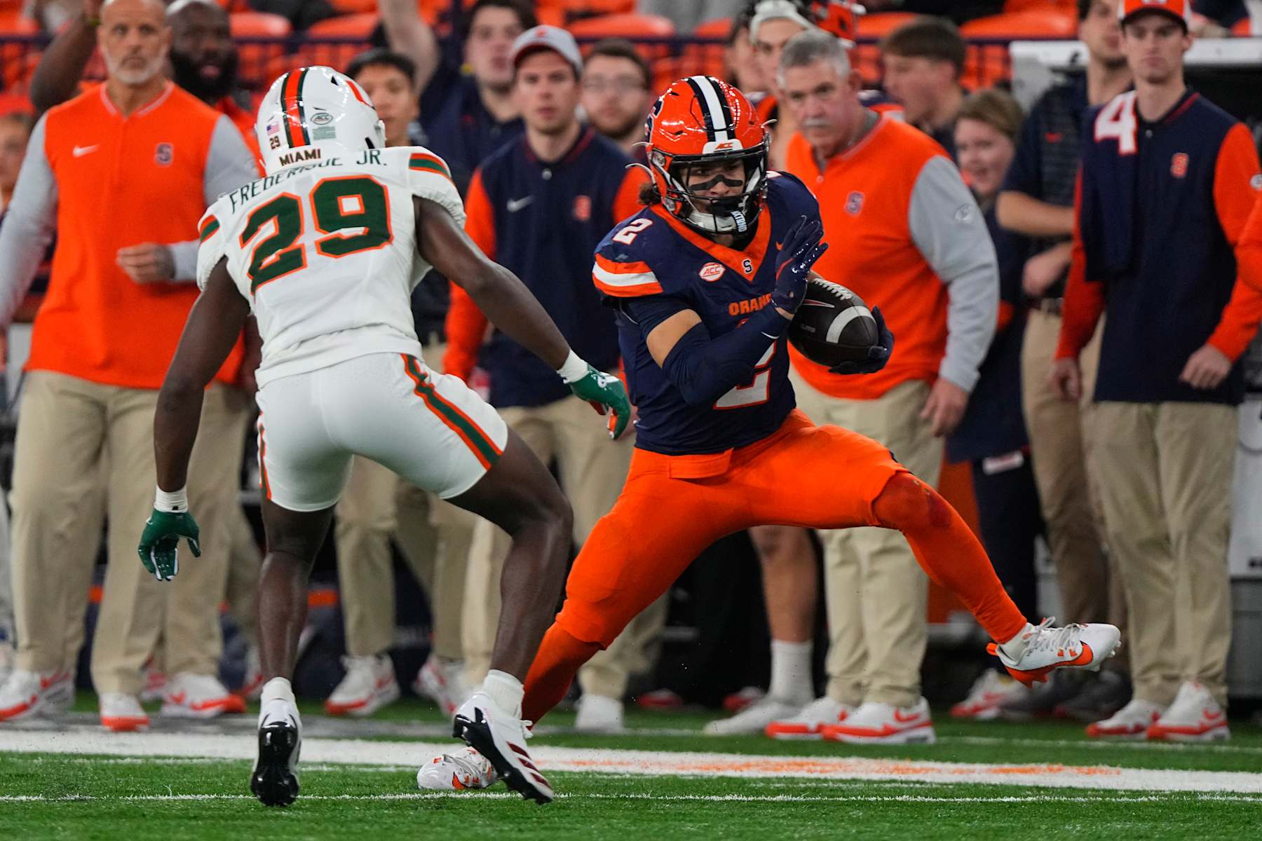 SYRACUSE, NY - NOVEMBER 30: Syracuse Orange Wide Receiver Trebor Pena (2) runs with the ball against Miami Hurricanes Defensive Back OJ Frederique Jr. (29) during the second half of the College Football game between the Miami Hurricanes and the Syracuse Orange on November 30, 2024, at the JMA Wireless Dome in Syracuse, NY. (Photo by Gregory Fisher/Icon Sportswire via Getty Images)