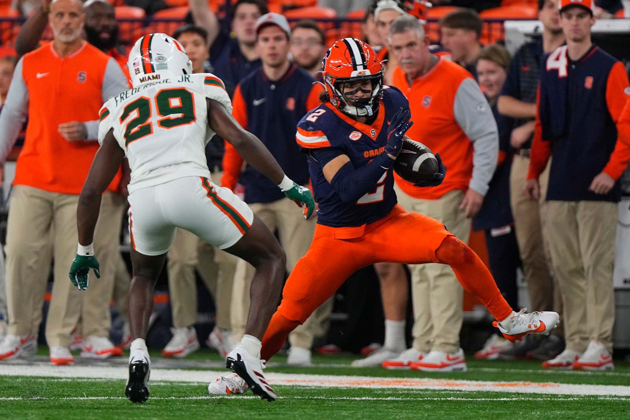 SYRACUSE, NY - NOVEMBER 30: Syracuse Orange Wide Receiver Trebor Pena (2) runs with the ball against Miami Hurricanes Defensive Back OJ Frederique Jr. (29) during the second half of the College Football game between the Miami Hurricanes and the Syracuse Orange on November 30, 2024, at the JMA Wireless Dome in Syracuse, NY. (Photo by Gregory Fisher/Icon Sportswire via Getty Images)