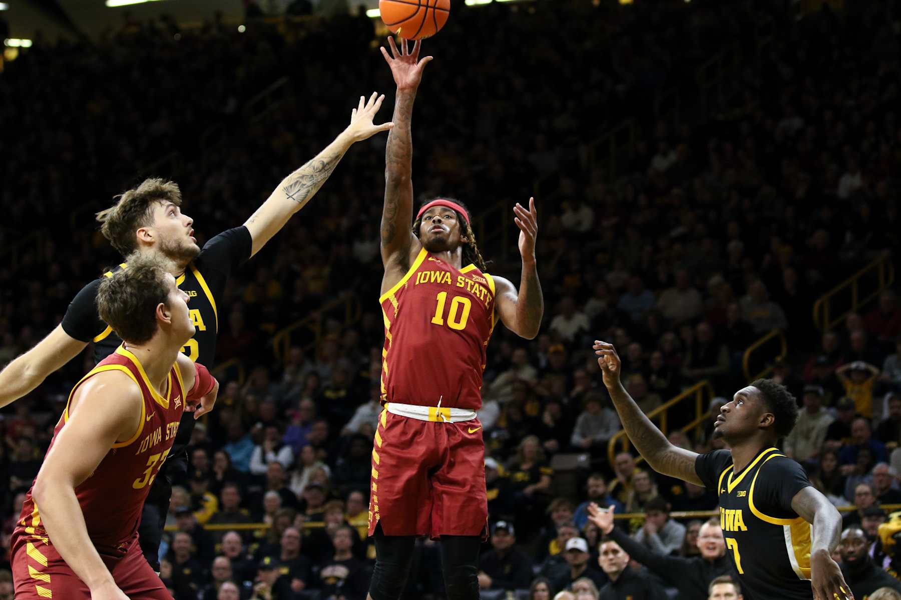 IOWA CITY, IOWA- DECEMBER 12:  Guard Keshon Gilbert #10 of the Iowa State Cyclones  takes a shot during the first half against forward Payton Sandfort #20 and forward Seydou Traore #7 of the Iowa Hawkeyes, at Carver-Hawkeye Arena on December 12, 2024 in Iowa City, Iowa.  (Photo by Matthew Holst/Getty Images)