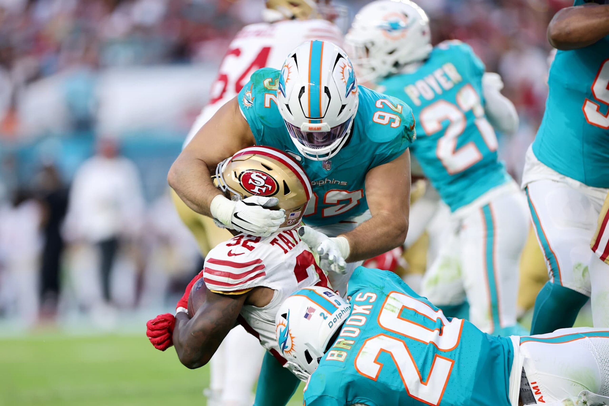 MIAMI GARDENS, FLORIDA - DECEMBER 22: Zach Sieler #92 of the Miami Dolphins tackles Patrick Taylor Jr. #32 of the San Francisco 49ers during the second quarter at Hard Rock Stadium on December 22, 2024 in Miami Gardens, Florida. (Photo by Carmen Mandato/Getty Images)