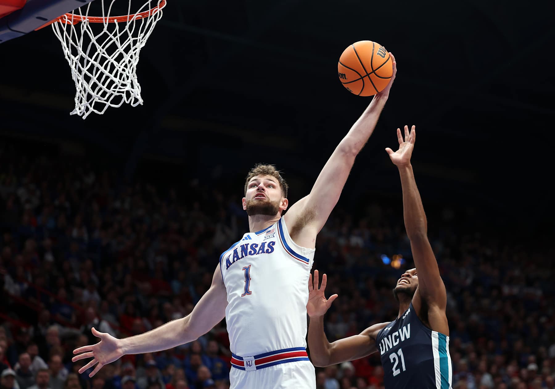 LAWRENCE, KANSAS - NOVEMBER 19:  Hunter Dickinson #1 of the Kansas Jayhawks grabs a rebound over Khamari McGriff #21 of the North Carolina-Wilmington Seahawks during the game at Allen Fieldhouse on November 19, 2024 in Lawrence, Kansas.  (Photo by Jamie Squire/Getty Images)