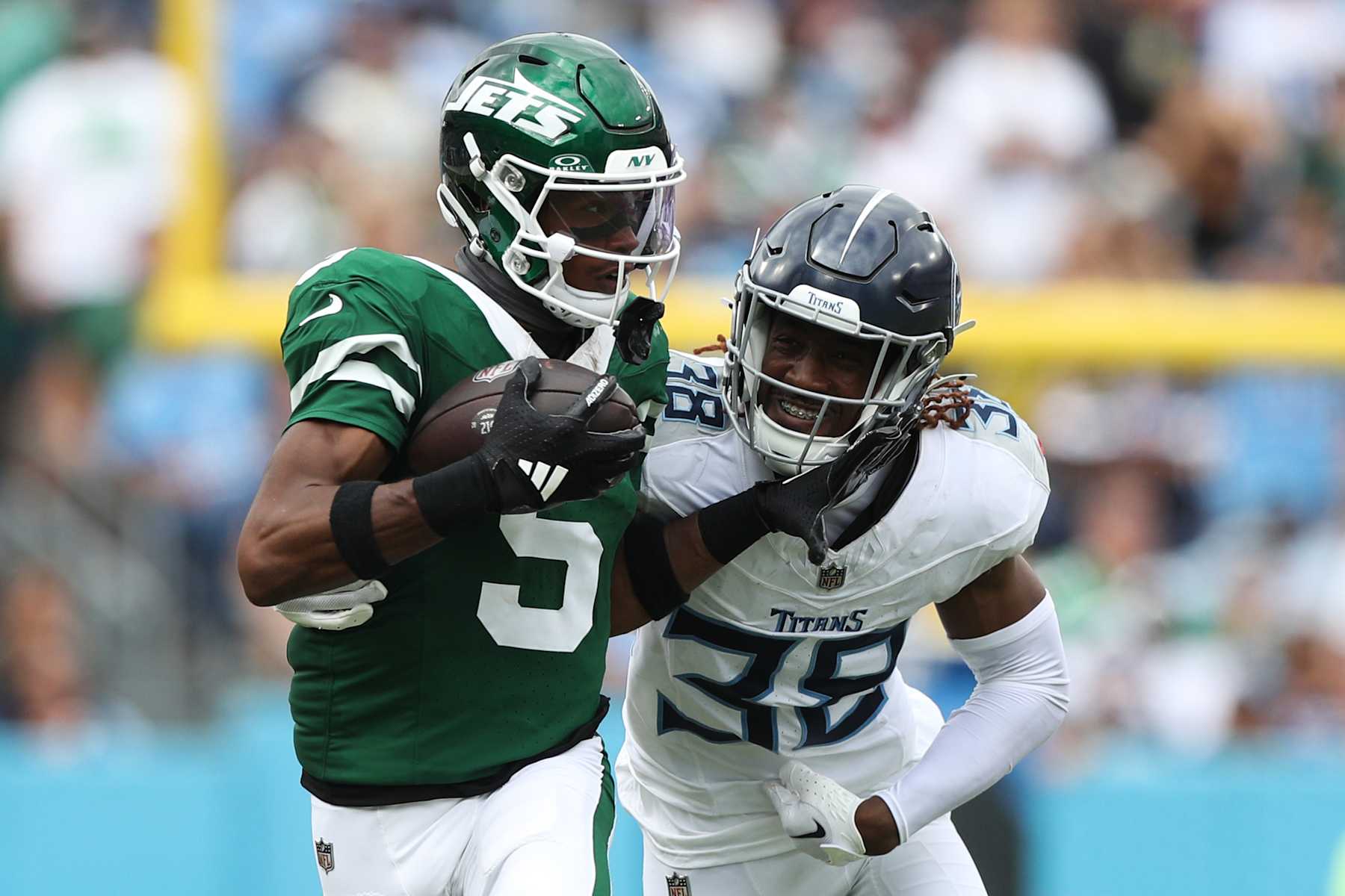 NASHVILLE, TENNESSEE - SEPTEMBER 15: Garrett Wilson #5 of the New York Jets runs with the ball as L'Jarius Sneed #38 of the Tennessee Titans looks to make a tackle during the second half at Nissan Stadium on September 15, 2024 in Nashville, Tennessee. (Photo by Justin Ford/Getty Images)