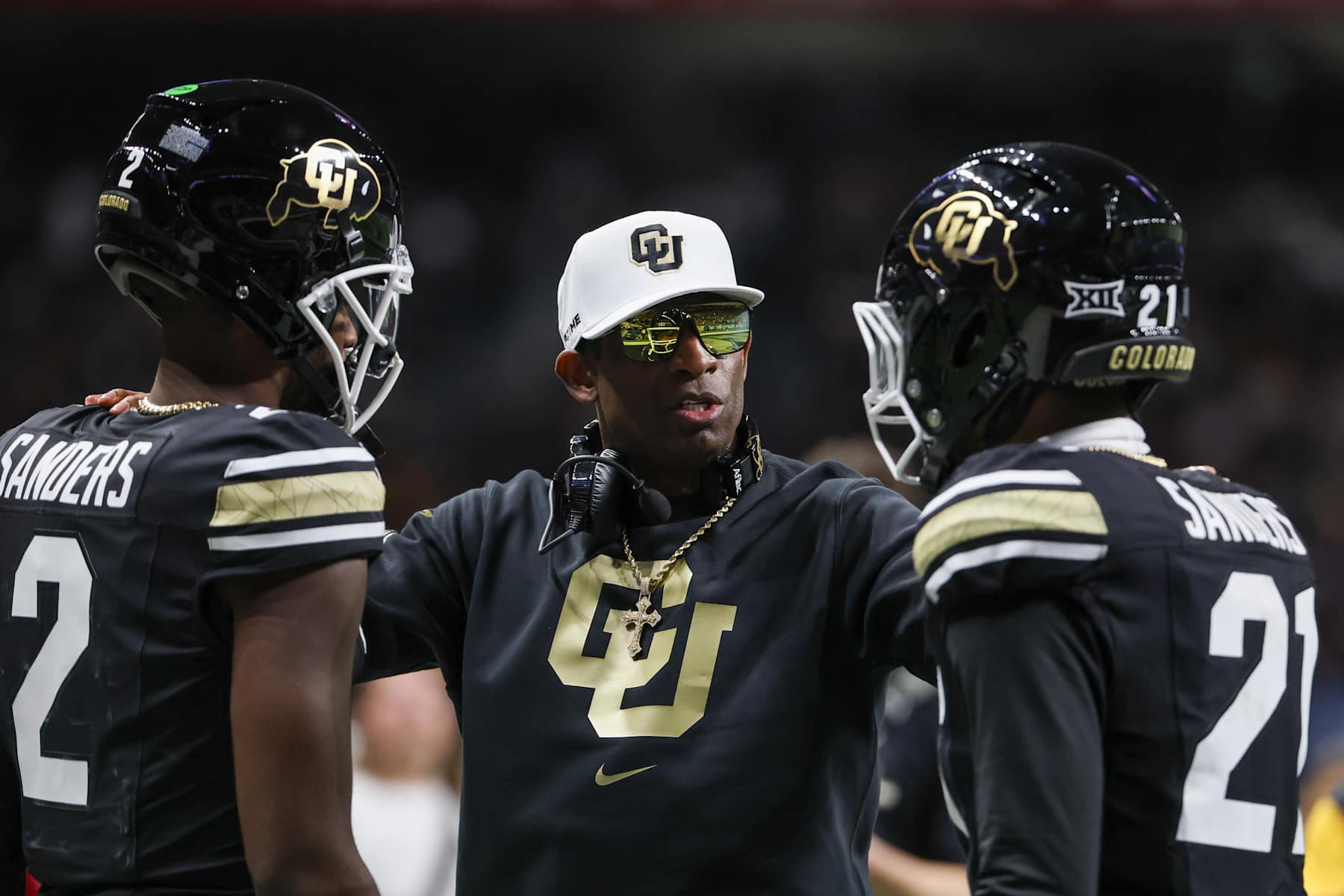 SAN ANTONIO, TX - DECEMBER 28: Colorado Buffaloes head coach Deion Sanders talks to Colorado Buffaloes quarterback Shedeur Sanders (2) and Colorado Buffaloes safety Shilo Sanders (21) before the football game between BYU Cougars and Colorado Buffalos on December 28, 2024, at the Alamodome in San Antonio, Texas. (Photo by David Buono/Icon Sportswire via Getty Images)