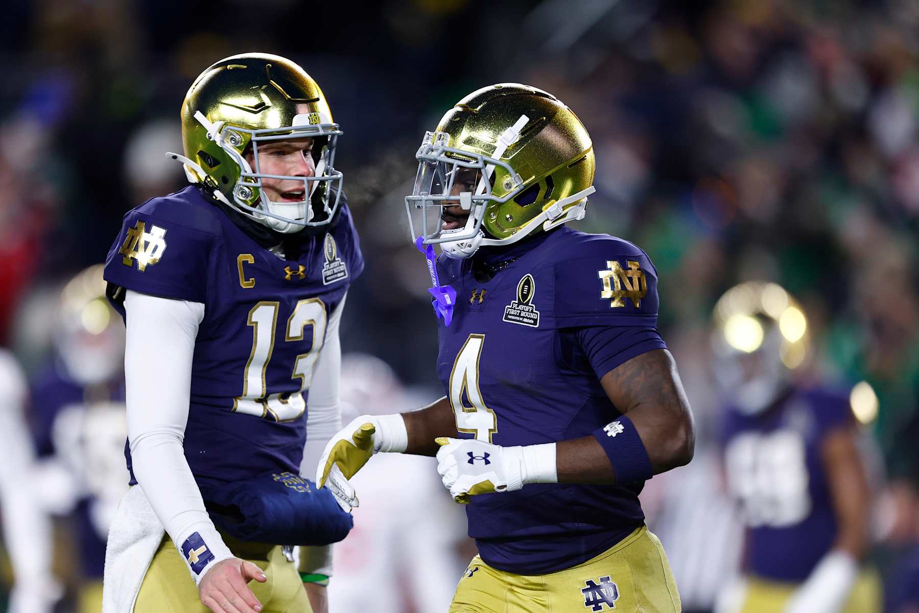 SOUTH BEND, IN - DECEMBER 20: Notre Dame Fighting Irish quarterback Riley Leonard (13) celebrates with Notre Dame Fighting Irish running back Jeremiyah Love (4) after his touchdown during the CFP first round game between the Indiana Hoosiers and Notre Dame Fighting Irish on December 20, 2024 at Notre Dame Stadium in South Bend, IN.  (Photo by Jeffrey Brown/Icon Sportswire via Getty Images)