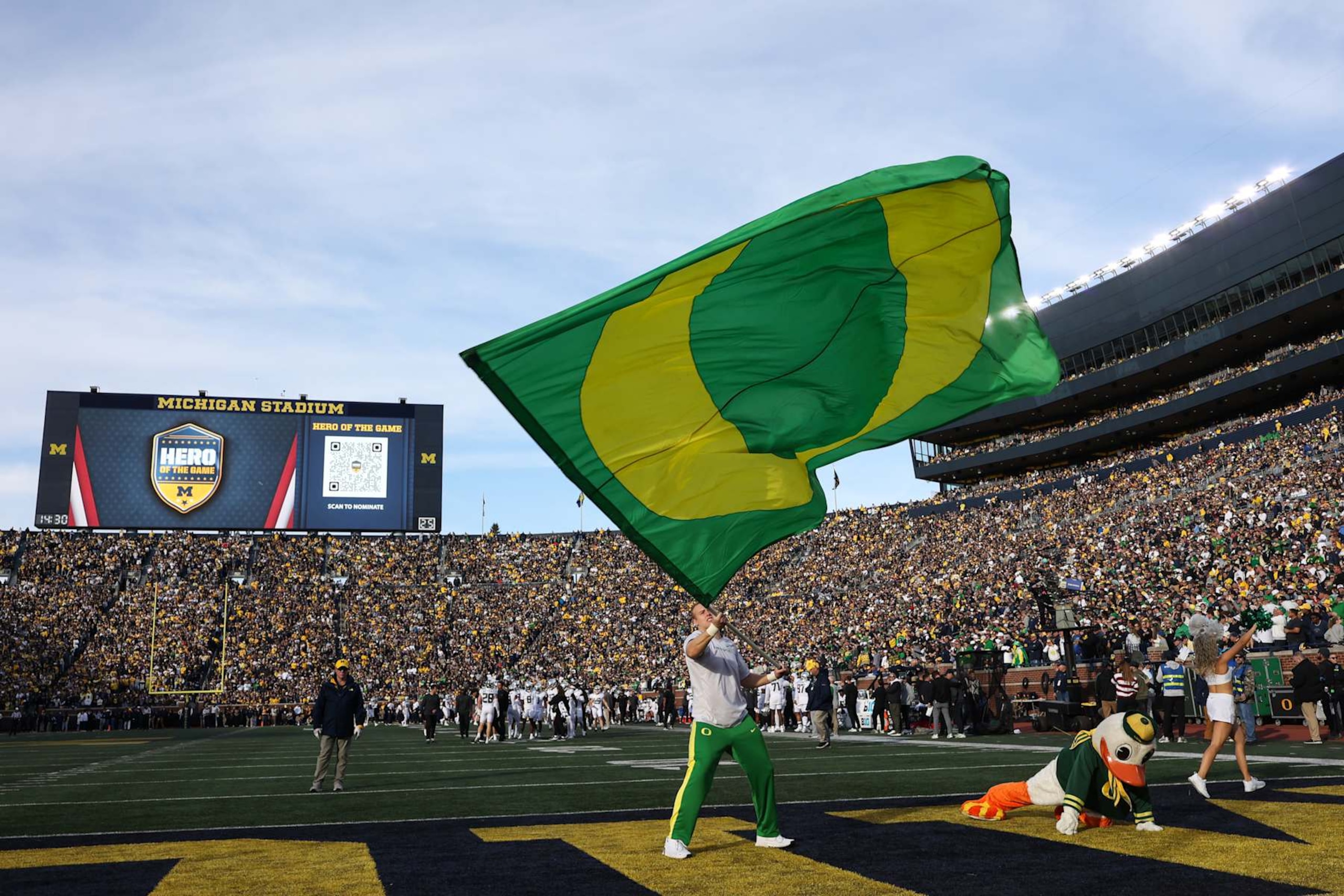 ANN ARBOR, MI - NOVEMBER 02:  An Oregon cheerleader waves a giant Oregon "O" logo flag after a touchdown during the second quarter of a Big Ten Conference college football game between the Oregon Ducks and the Michigan Wolverines on November 2, 2024 at Michigan Stadium in Ann Arbor, Michigan.  (Photo by Scott W. Grau/Icon Sportswire via Getty Images)