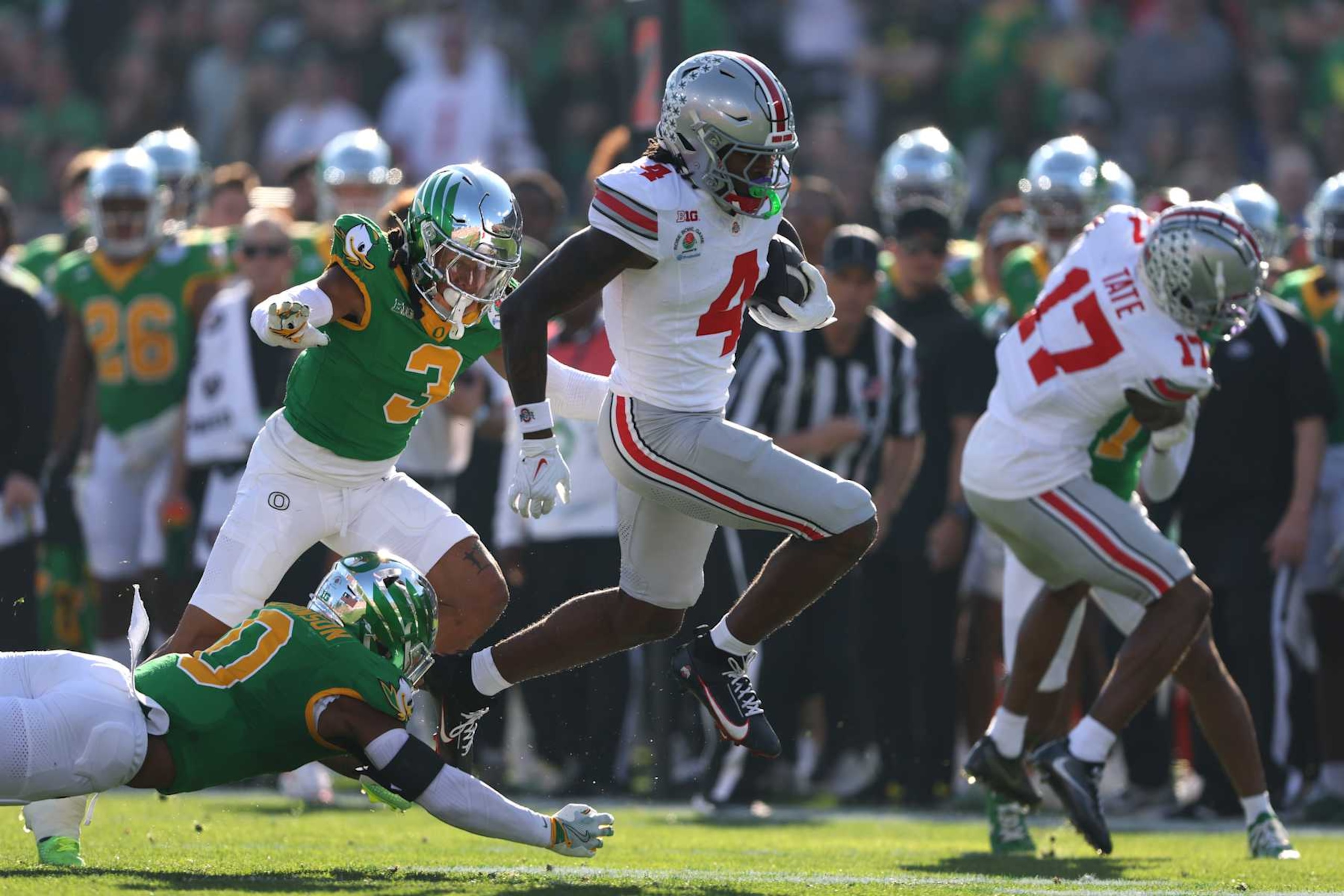PASADENA, CALIFORNIA - JANUARY 01: Jeremiah Smith #4 of the Ohio State Buckeyes runs the ball against Tysheem Johnson #0 of the Oregon Ducks during the first quarter in the Rose Bowl Game Presented by Prudential at Rose Bowl Stadium on January 01, 2025 in Pasadena, California. (Photo by Sean M. Haffey/Getty Images)