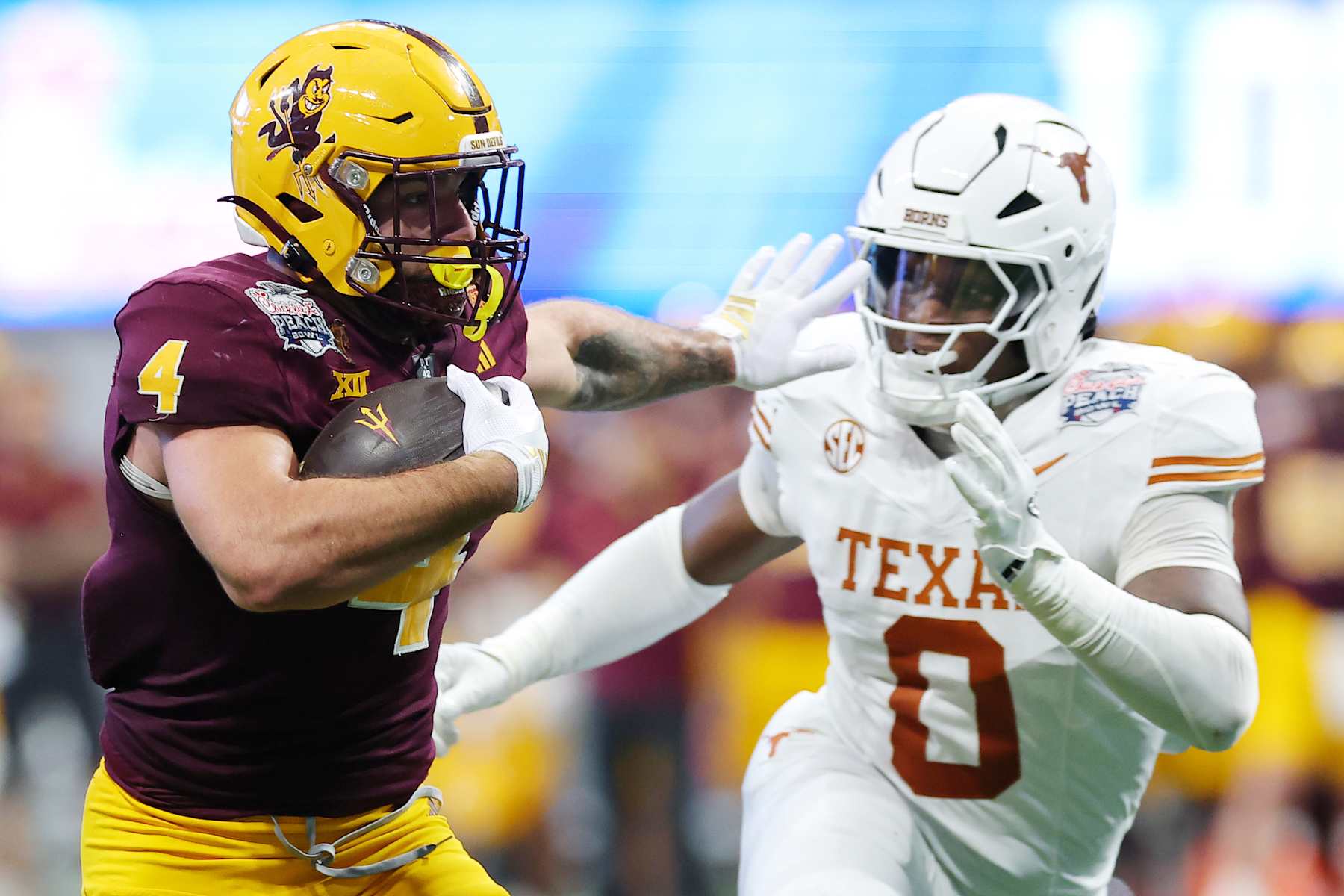 ATLANTA, GEORGIA - JANUARY 01: Cam Skattebo #4 of the Arizona State Sun Devils runs the ball against Anthony Hill Jr. #0 of the Texas Longhorns during the third quarter in the Chick-fil-A Peach Bowl at Mercedes-Benz Stadium on January 01, 2025 in Atlanta, Georgia.  (Photo by Kevin C. Cox/Getty Images)