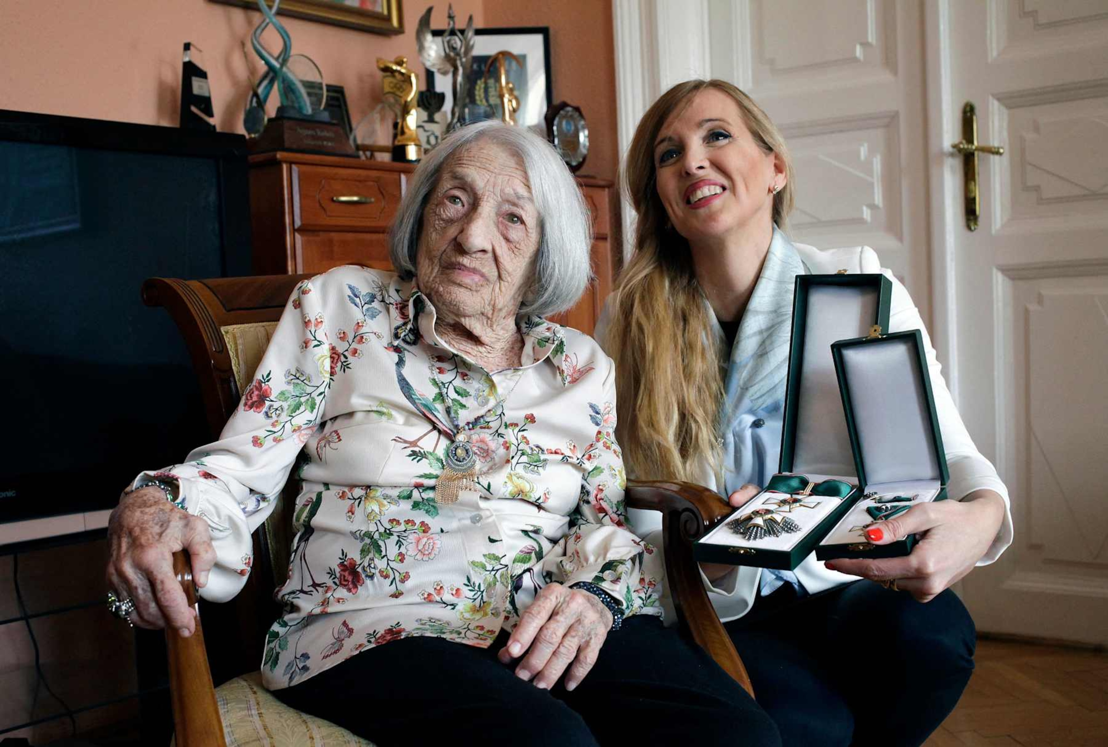 Hungarian-Israeli retired Olympic and world champion artistic gymnast Agnes Keleti (L) poses with Hungarian State Secretary for Sports Tunde Szabo after she was presented with the Hungarian Order of Merit (cross with star) in Keleti's apartment in Budapest on April 7, 2022. - 101-year-old Agnes Keleti, a survivor of the Holocaust, won 10 Olympic medals in Helsinki (1952) and in Melbourne (1956) and is considered to be the world's oldest living Olympian. (Photo by Peter Kohalmi / AFP) (Photo by PETER KOHALMI/AFP via Getty Images) Hungarian-Israeli retired Olympic and world champion artistic gymnast Agnes Keleti (L) poses with Hungarian State Secretary for Sports Tunde Szabo after she was presented with the Hungarian Order of Merit (cross with star) in Keleti's apartment in Budapest on April 7, 2022. - 101-year-old Agnes Keleti, a survivor of the Holocaust, won 10 Olympic medals in Helsinki (1952) and in Melbourne (1956) and is considered to be the world's oldest living Olympian. (Photo by Peter Kohalmi / AFP) (Photo by PETER KOHALMI/AFP via Getty Images)