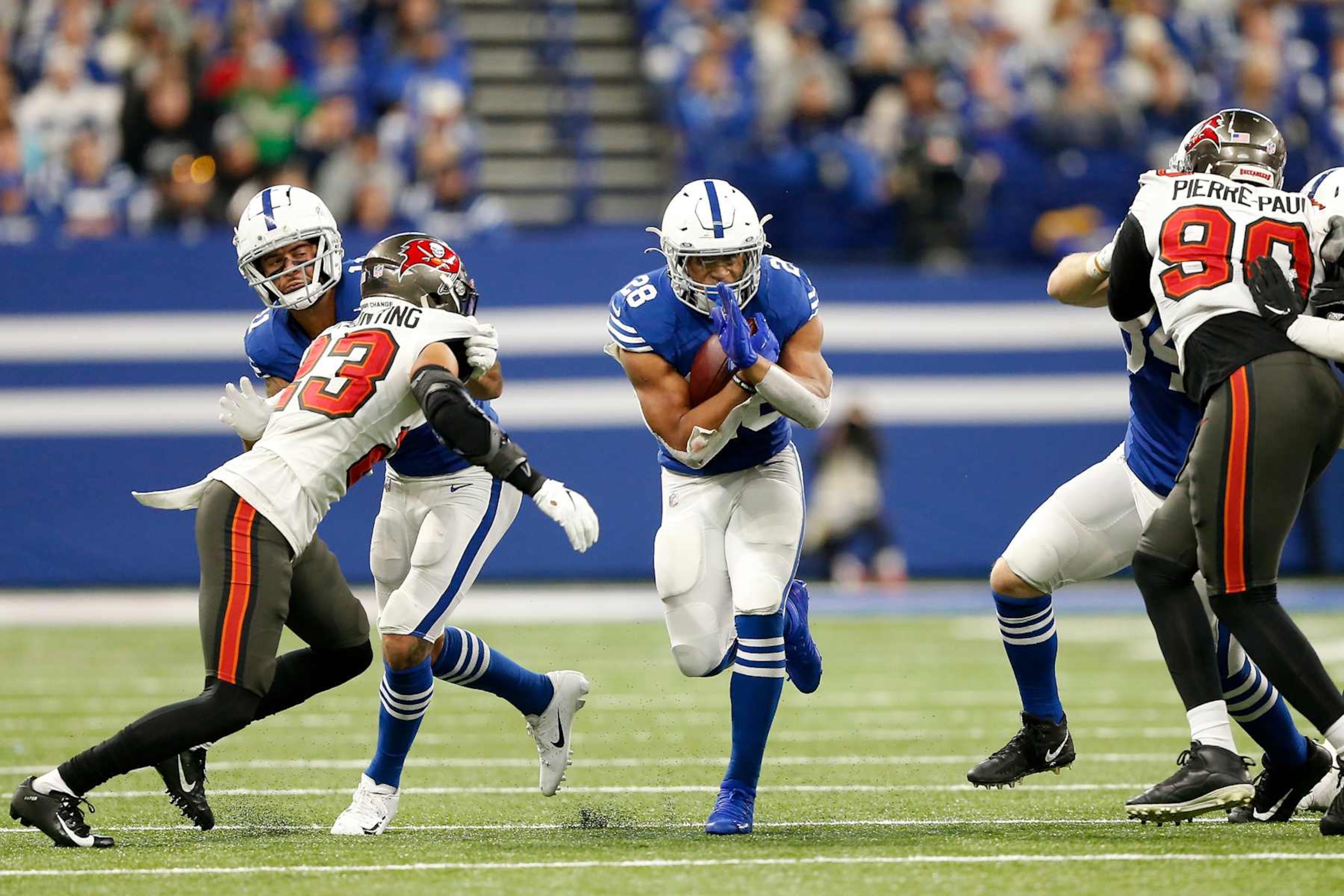 INDIANAPOLIS, IN - NOVEMBER 28: Indianapolis Colts Running Back Jonathan Taylor (28) runs through the hole during a NFL game between the Tampa Bay Buccaneers and the Indianapolis Colts on November 28, 2021, at Lucas Oil Stadium in Indianapolis, IN. (Photo by Jeffrey Brown/Icon Sportswire via Getty Images) INDIANAPOLIS, IN - NOVEMBER 28: Indianapolis Colts Running Back Jonathan Taylor (28) runs through the hole during a NFL game between the Tampa Bay Buccaneers and the Indianapolis Colts on November 28, 2021, at Lucas Oil Stadium in Indianapolis, IN. (Photo by Jeffrey Brown/Icon Sportswire via Getty Images)